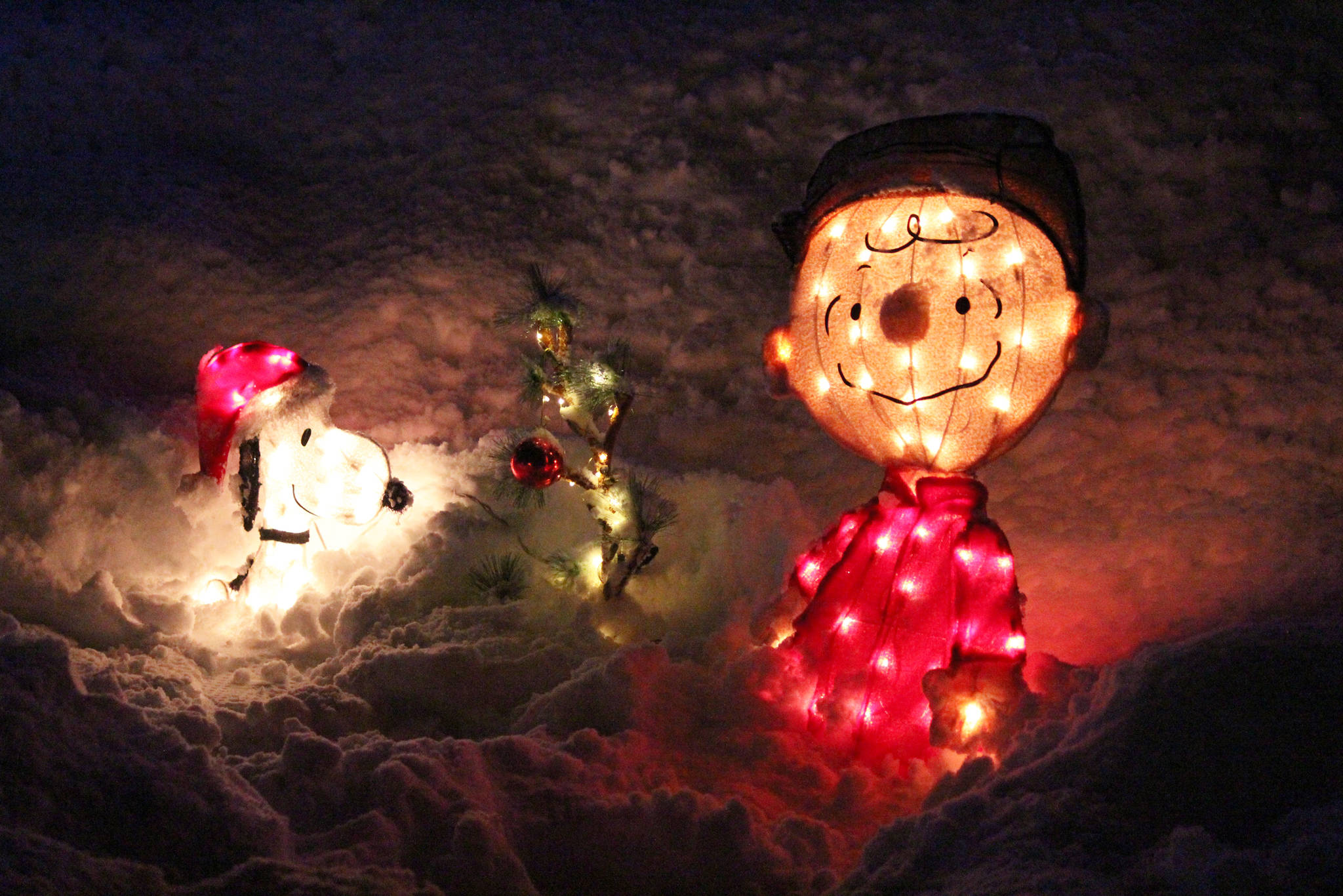 Lights made to look like the characters of Snoopy and Charlie Brown rest in the snow Friday, Dec. 15, 2018 at the Bear Creek Winery Garden Lights at the winery in Kachemak City, Alaska. The lights will run one more weekend, from 5-7 p.m. Friday and Saturday, Dec. 21-22. (Photo by Megan Pacer/Homer News)