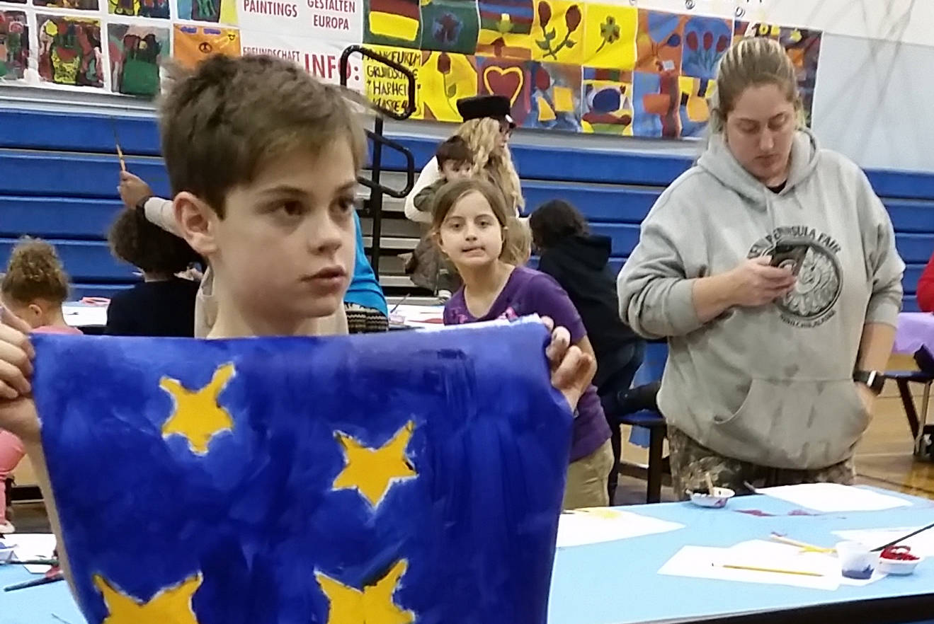 Chapman 4th-grade student Miles Tressler displays a Flag of Peace he painted on Dec. 6, 2018 at Chapman School in Anchor Point, Alaska. (Photo provided)