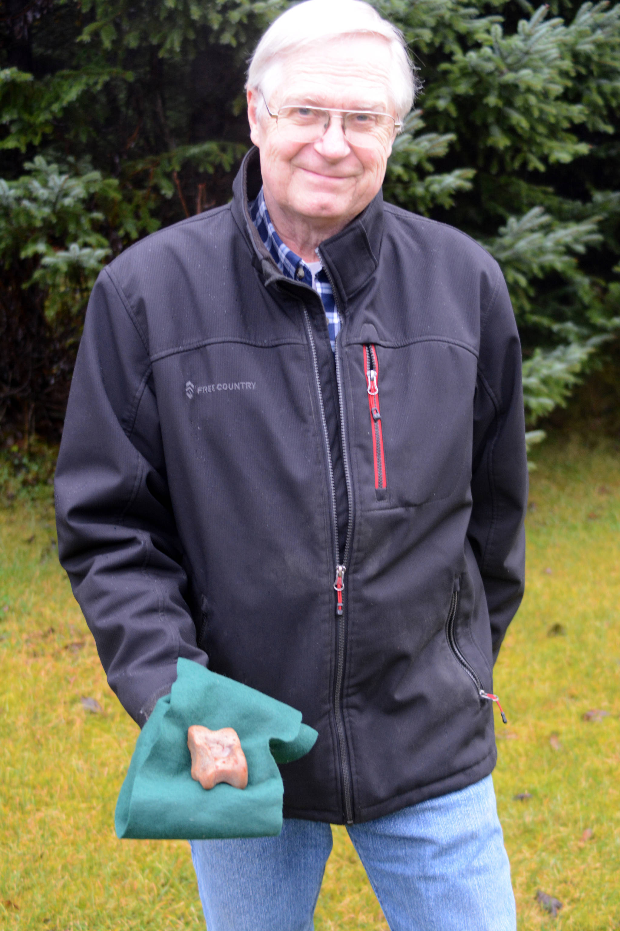 In this photo taken on Nov. 26, 2018, Don Henry holds an astagalus, or ankle bone, he found on the Mud Bay side of the Homer Spit earlier this month. (Homer News file photo)