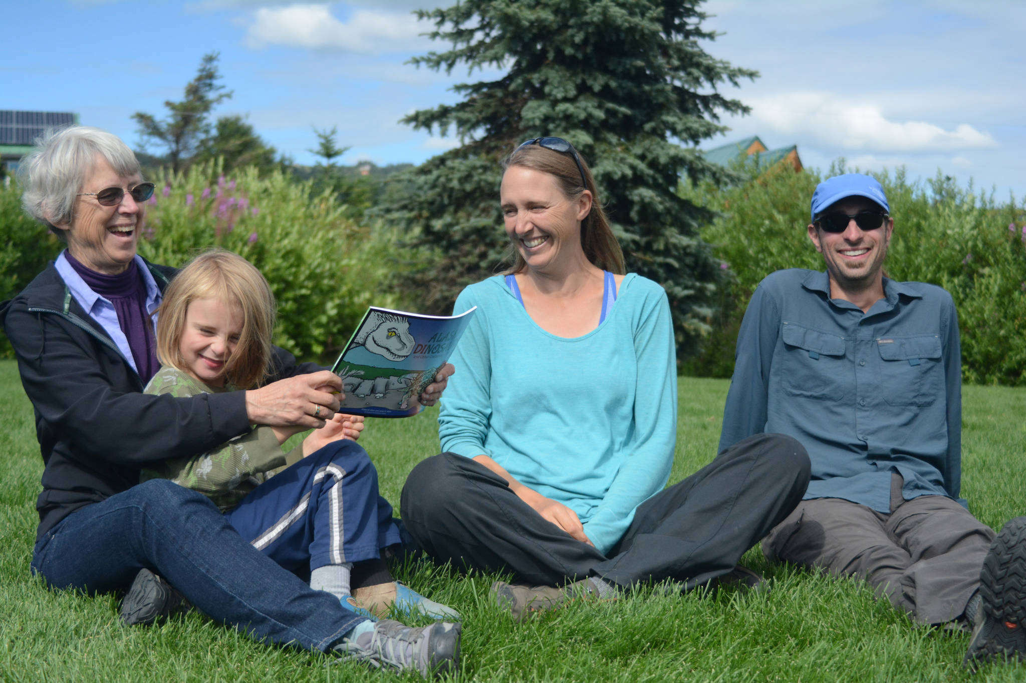 Janet Klein, left, holds her grandson, Sylas Reising, 4, while she visits with her daughter, Deborah Klein, center, and son-in-law George Reising, right, at Bishop’s Beach, Homer, Alaska, on Aug. 9, 2018. Not shown is Kai Reising, 6. Silas and Kai were the inspiration for the Klein’s “color and learn” book, “Alaska’s Dinosaurs and Other Cretaceous Creatures.” (Homer News file photo)