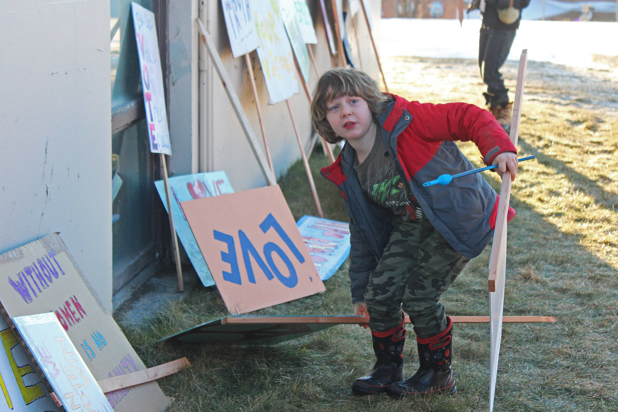 Evan Spencer, 6, of Anchor Point, opts for a different sign to carry Saturday, Jan. 19, 2019 at the third Women’s March on Homer at the Homer Education and Recreation Complex in Homer, Alaska. (Photo by Megan Pacer/Homer News)