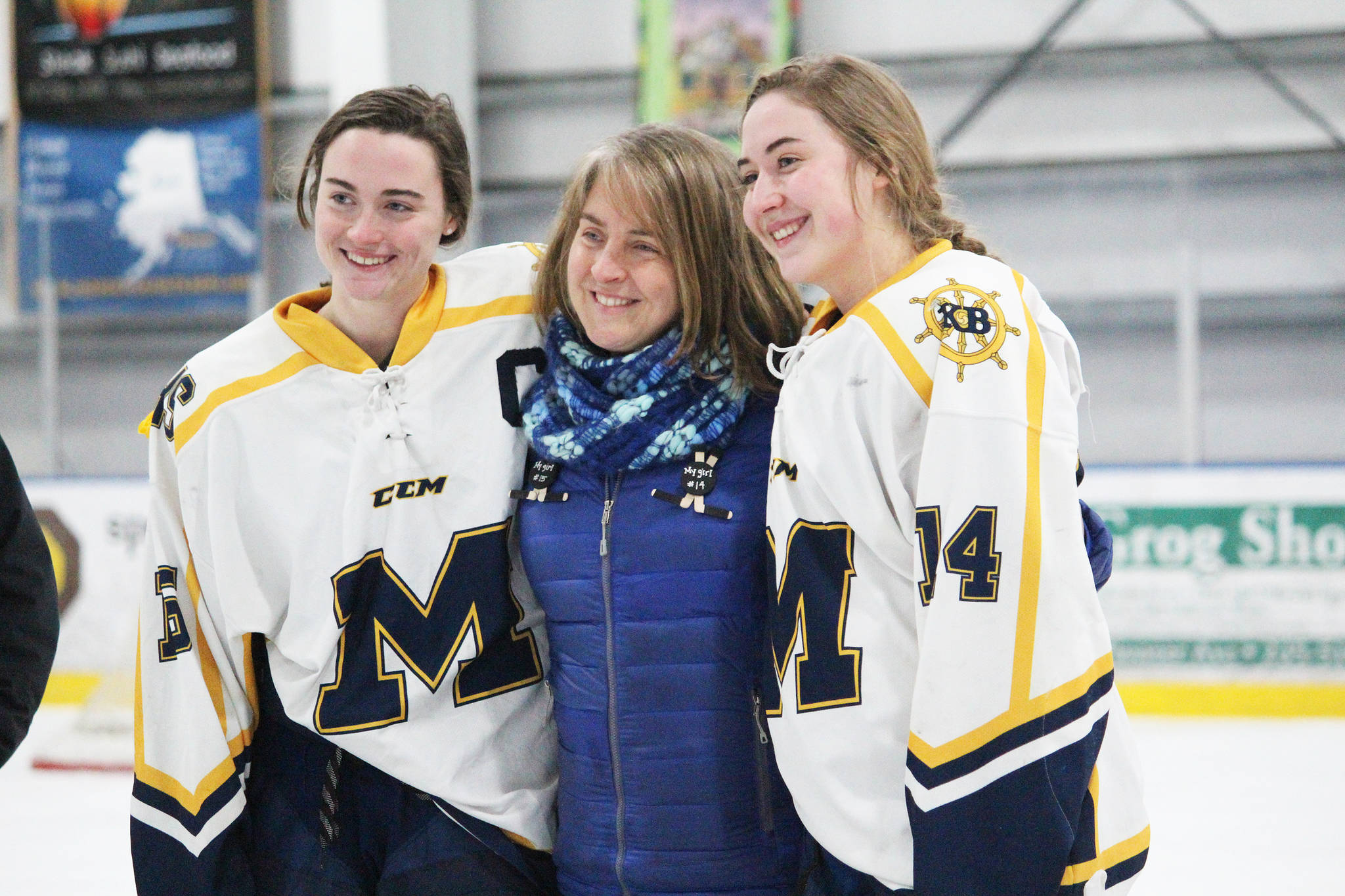 Homer seniors Ali McCarron (left) and Brenna McCarron (Right) are honored with they mom, Julie, on Senior Night for the Homer High School hockey team Thursday, Jan. 24, 2019 at Kevin Bell Arena in Homer, Alaska. The Mariners defeated Houston High School 10-1. (Photo by Megan Pacer/Homer News)