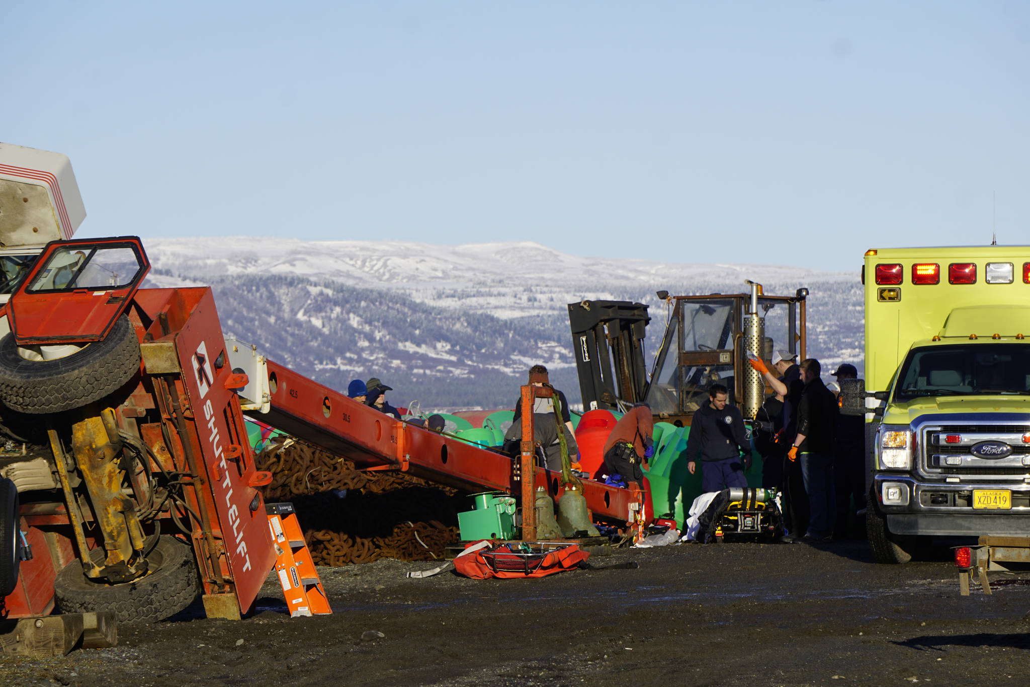 Homer Volunteer Fire Department emergency medical technicians treat a person injured when a crane tipped over at the Pioneer Dock on the Homer Spit at about 1:55 p.m. Jan. 31, 2019, in Homer, Alaska. (Photo by Michael Armstrong/Homer News.)