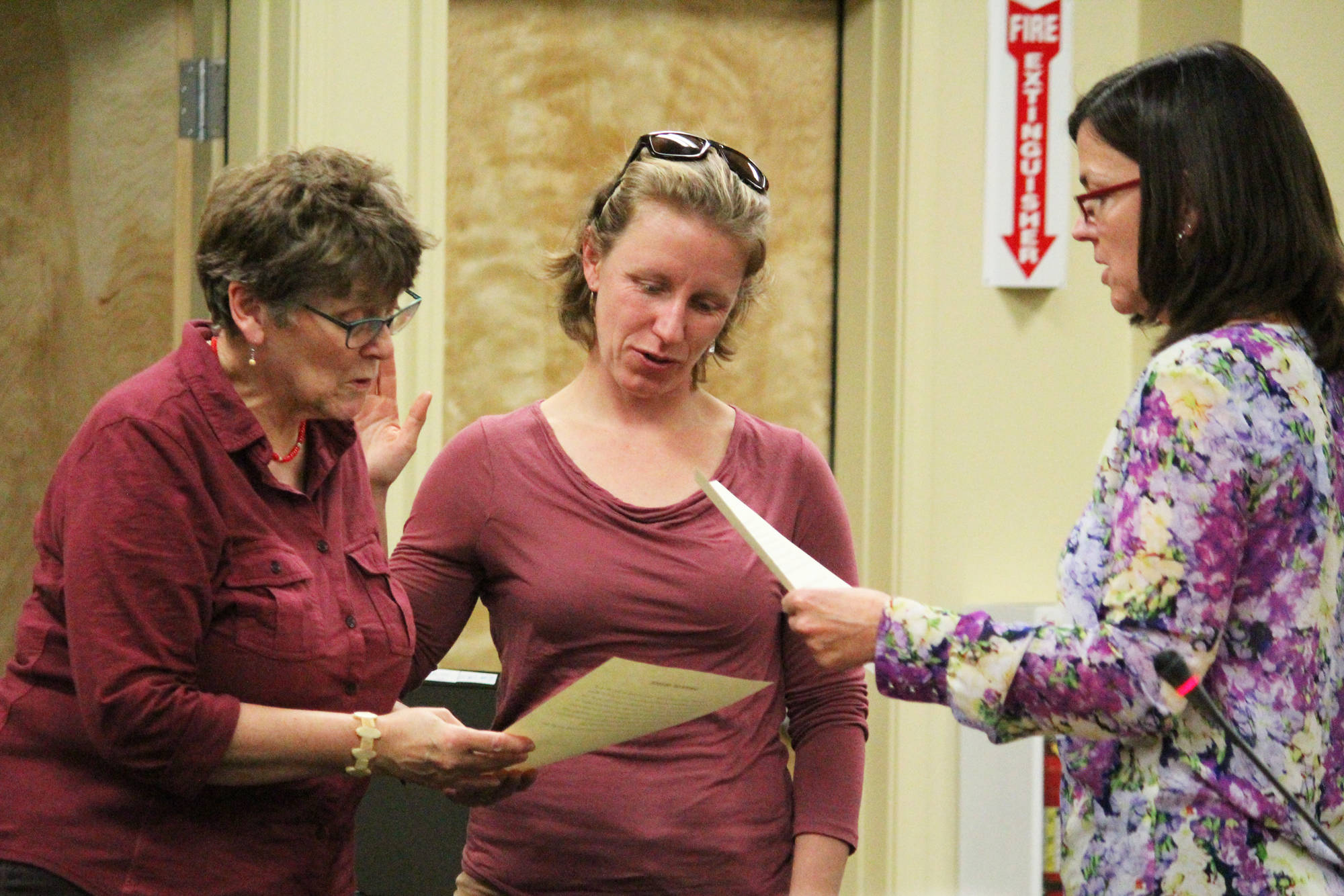 Caroline Venuti (left) and Rachel Lord (center) are sworn in as Homer City Council members by City Clerk Melissa Jacobsen (right) on Monday, Oct. 9, 2017 at the Cowles Council Chambers in Homer, Alaska. (Photo by Megan Pacer/Homer News)