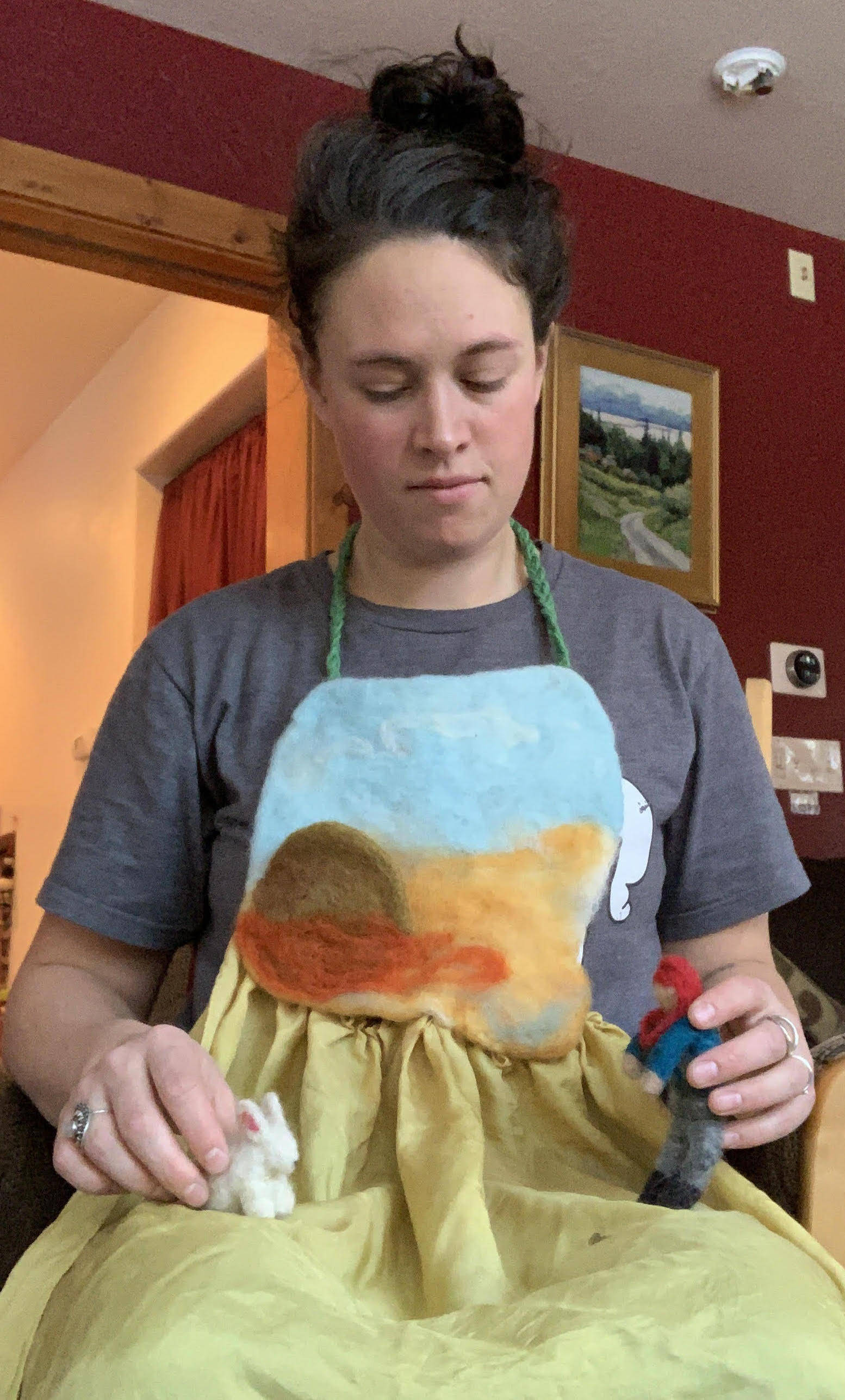 Hanna Young shows her story apron, a surface for telling stories using her felted characters. (Photo provided)