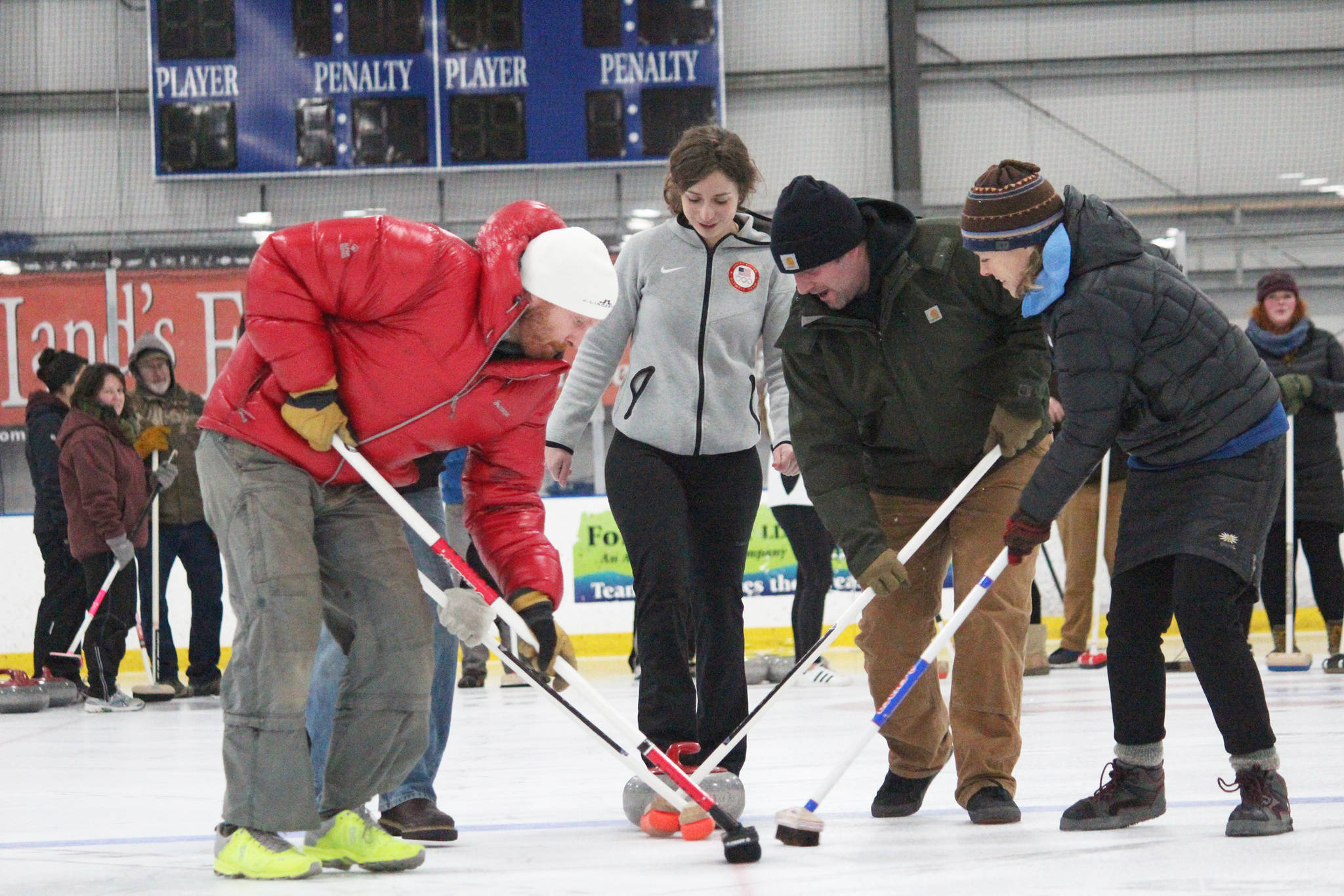 Former Olympic curler Jessica Schultz coaches a group of people as they practice sweeping a curling stone Saturday, Jan. 12, 2019 at the Kevin Bell Ice Arena in Homer, Alaska during a fundraiser event for the Homer Curling Club. (Photo by Megan Pacer/Homer News)