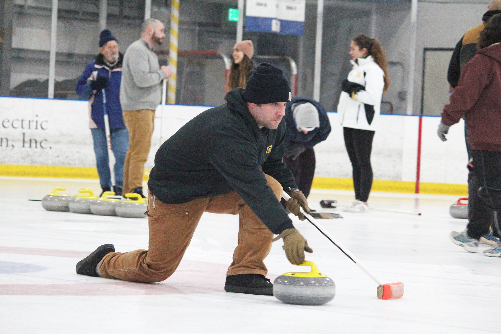 Chuck Bowman slides a curling stone during a Learn to Curl clinic Saturday, Jan. 12, 2019 at the Kevin Bell Ice Arena in Homer, Alaska. The clinic, a fundraiser for the Homer Curling Club, was taught by former Olympic curler Jessica Schultz. (Photo by Megan Pacer/Homer News)