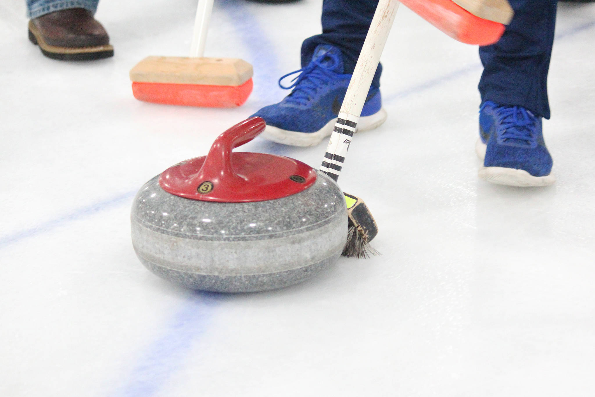 A curling stone is swept across the ice during a Learn to Curl clinic Saturday, Jan. 12, 2019 at Kevin Bell Ice Arena in Homer, Alaska. The clinic was a fundraiser for the Homer Curling Club. (Photo by Megan Pacer/Homer News)