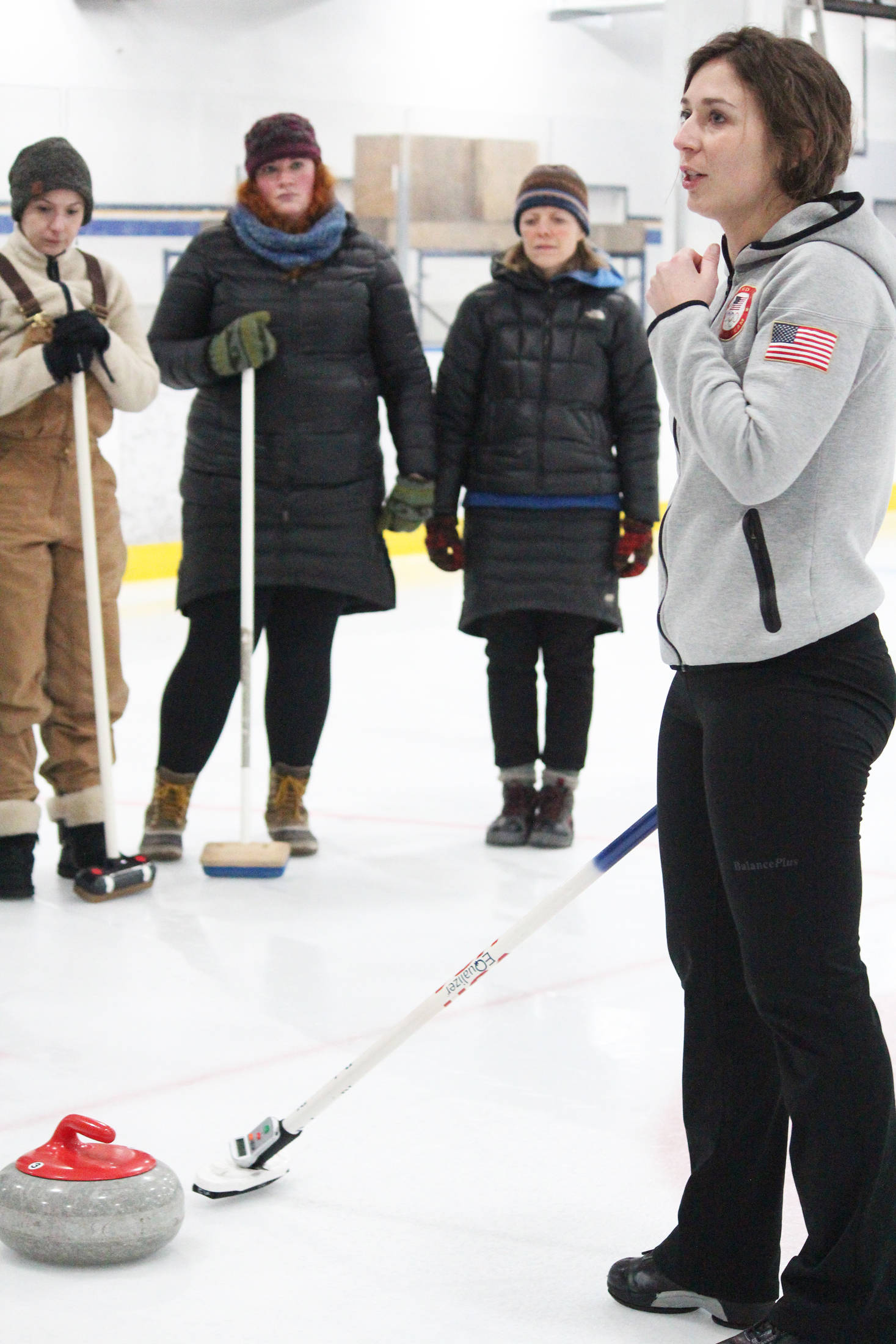 Former Olympic curler Jessica Schultz explains the basics of the sport to a group of people Saturday, Jan. 12, 2019 at the Kevin Bell Ice Arena in Homer, Alaska during a fundraiser event for the Homer Curling Club. (Photo by Megan Pacer/Homer News)