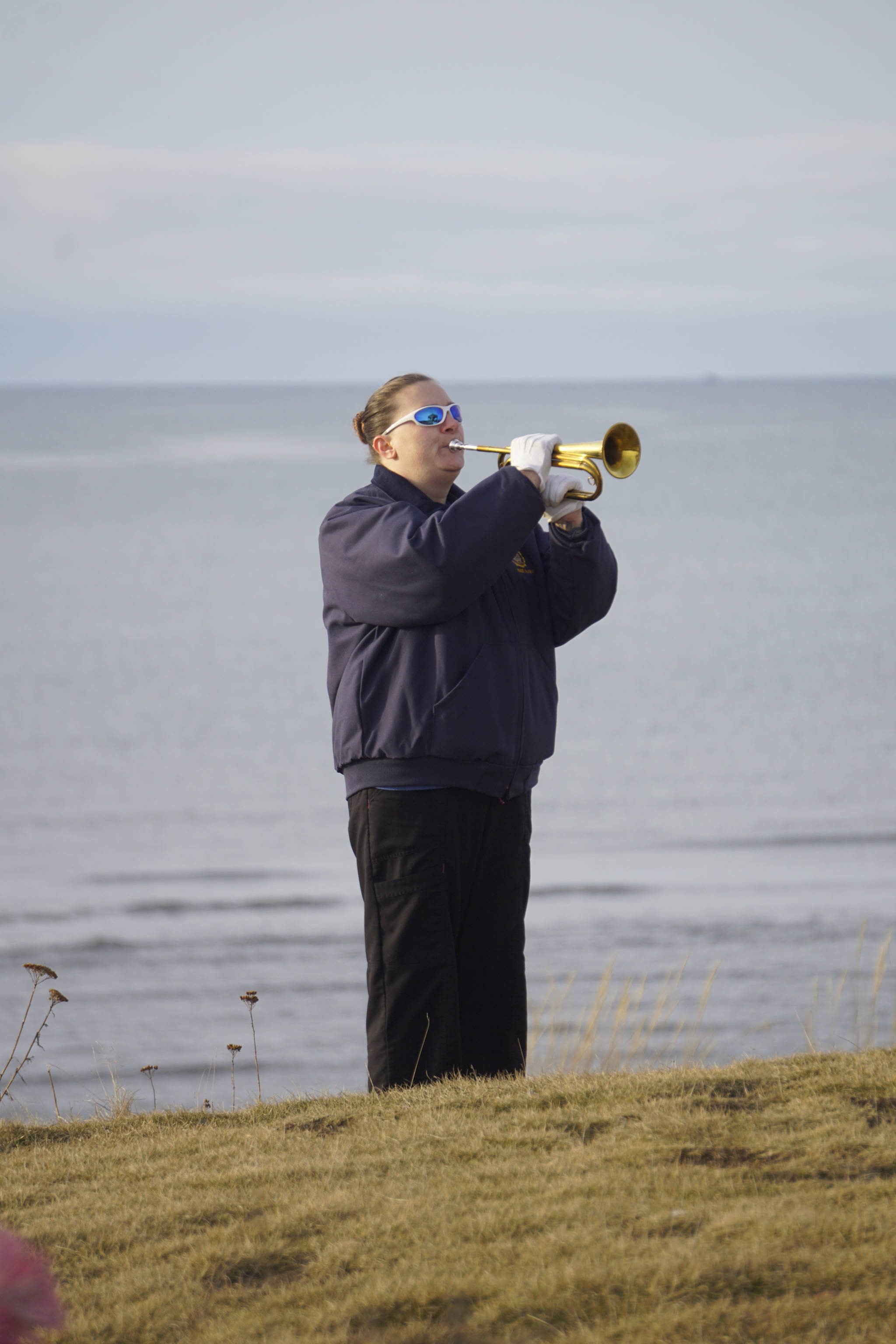 Cristy Hill plays “Taps” at a memorial service for Chief Warrant Officer Michael Kozloski on Friday morning, Feb. 8, 2019, at the Seafarer’s Memorial on the Homer Spit, Homer, Alaska. (Photo by Michael Armstrong/Homer News)