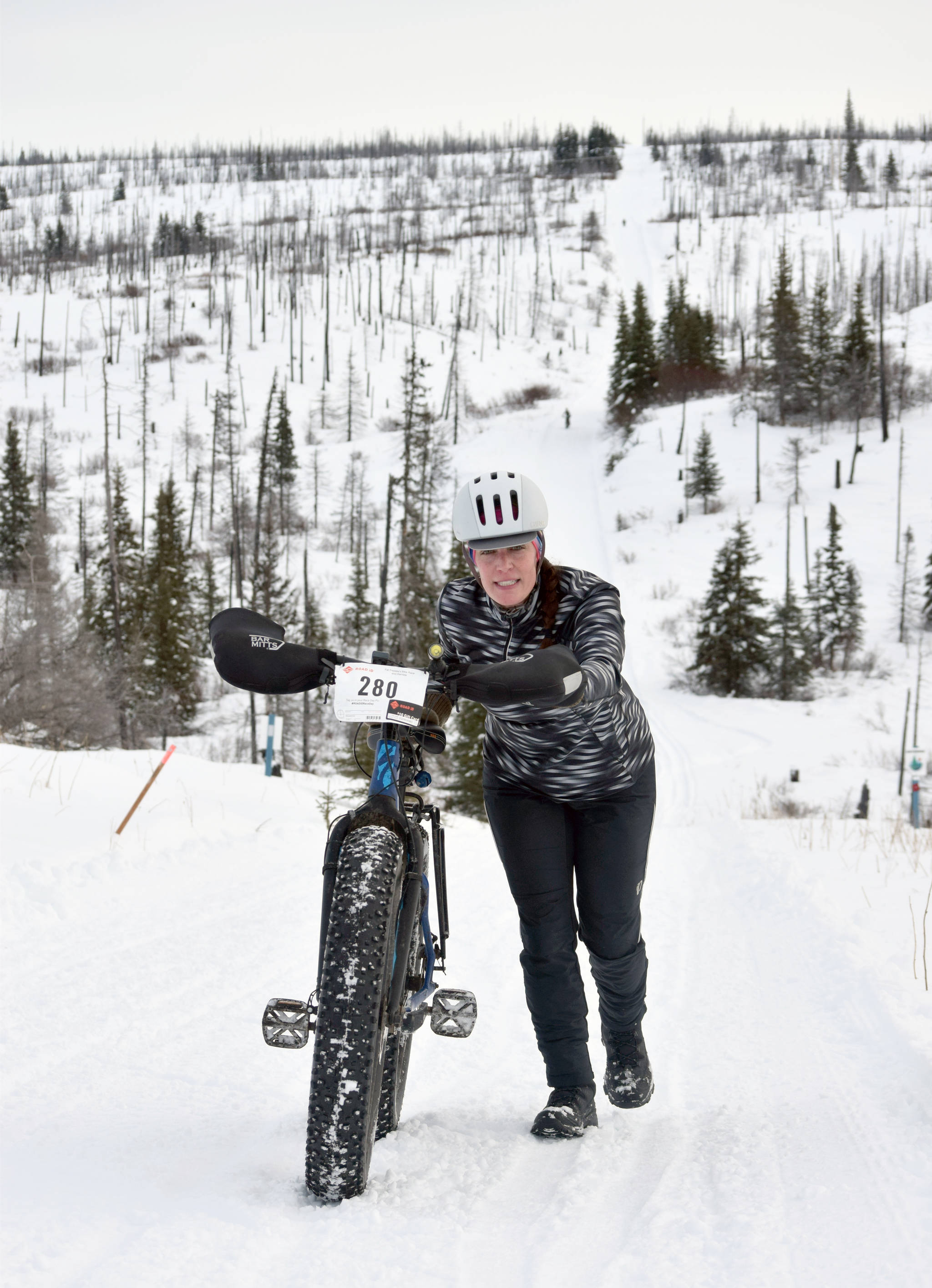 Simone Owens pushes her bike up a hill during Fat Freddie’s Bike Race and Ramble on Saturday, Feb. 9, 2019, in the Caribou Hills near Freddie’s Roadhouse. (Photo by Jeff Helminiak/Peninsula Clarion)
