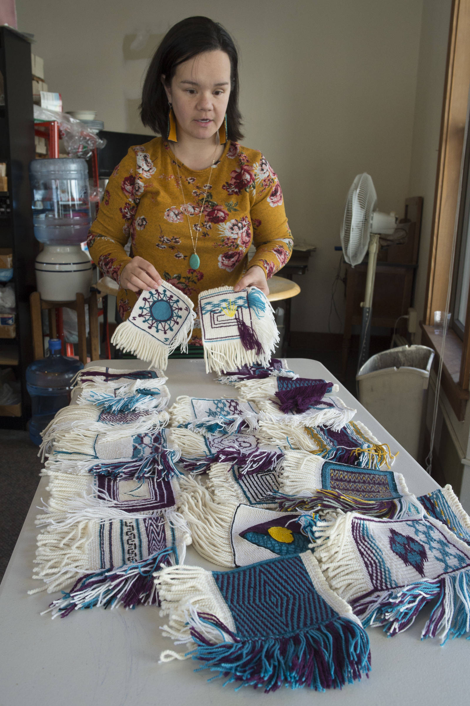 Weaver Lily Hope lays out woven squares for a new project called the Giving Strength Robe on Friday, Feb. 15, 2019. Hope is organizing dozens of Chilkat and Ravenstail weavers from all over North America to weave 5-inch-by-5-inch squares that will be combined to make one traditional indigenous robe. Once completed, the robe will be given to Aiding Women in Abuse and Rape Emergencies (AWARE). (Michael Penn | Juneau Empire)