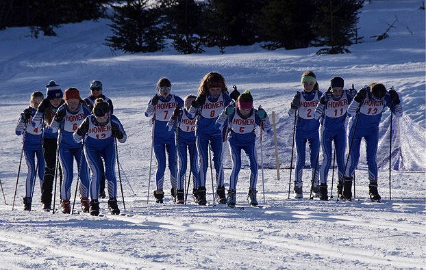 The Homer Husky girls at the starting line during a Friday, Feb. 16, 2019 ski meet near Homer, Alaska. Left to right: Leah Dunn, Lawson Alexson-Walls, Sidney Flora, Hannah Stonorov, Bryce Glidden, Elsa Otis, Alana Houlihan, Eryn Field, Elena Badajos, Frida Renner and Ireland Styvar. Homer High School skier and the sweeper for the race, Katia Holmes, is in the background. (Photo courtesy Mike Gracz)
