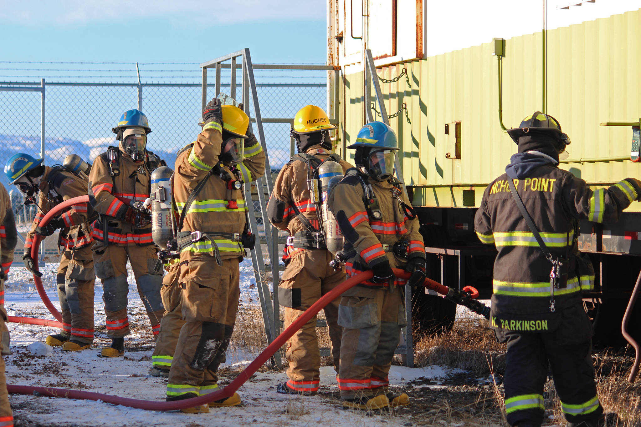 Firefighters from multiple agencies prepare to enter a structure with a fire burning inside it as part of a live fire exercise Saturday, Feb. 23, 2019 at the Homer Volunteer Fire Department’s fire training facility on Freight Dock Road in Homer, Alaska. Student volunteers rom Anchor Point Emergency Services, Homer Volunteer Fire Department, Ninilchik Emergency Services, and Central Emergency Services attended the drill as part of a joint Firefighter I class they are attending hosted by Anchor Point Fire and HVFD. (Photo by Megan Pacer/Homer News)