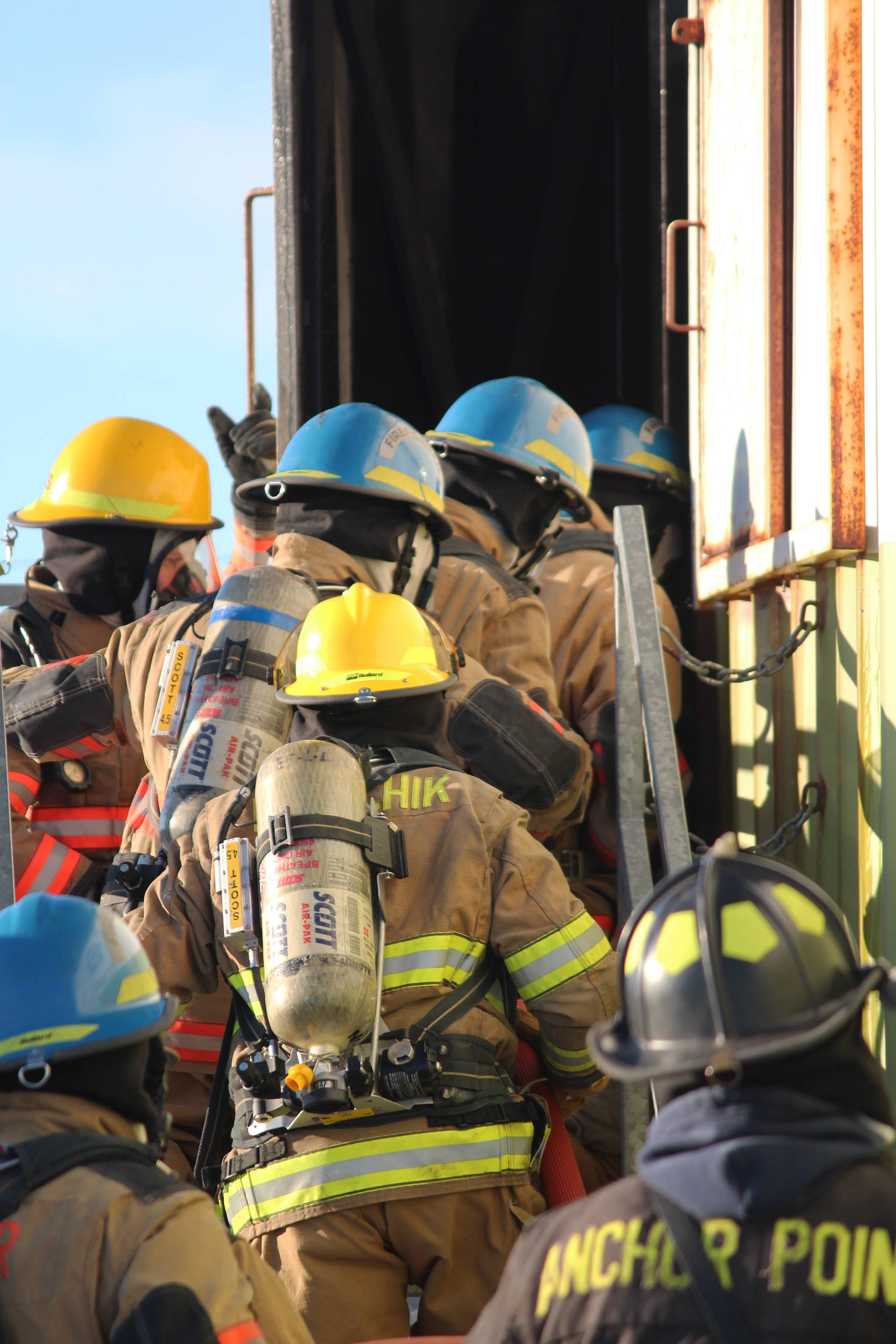 Firefighters from multiple agencies enter a structure with a fire burning inside it as part of a live fire exercise Saturday, Feb. 23, 2019 at the Homer Volunteer Fire Department’s fire training facility on Freight Dock Road in Homer, Alaska. Student volunteers rom Anchor Point Emergency Services, Homer Volunteer Fire Department, Ninilchik Emergency Services, and Central Emergency Services attended the drill as part of a joint Firefighter I class they are attending hosted by Anchor Point Fire and HVFD. (Photo by Megan Pacer/Homer News)