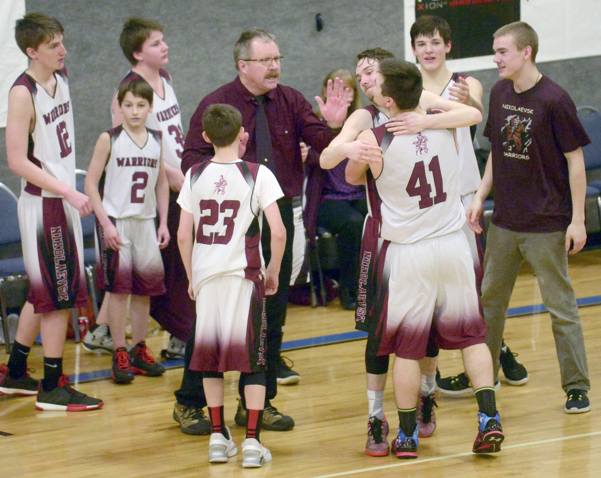 Nikolaevsk coach Steve Klaich celebrates with his team after winning his first Peninsula Conference title in his 30th season at the helm Friday at Cook Inlet Academy in Soldotna. (Photo by Jeff Helminiak/Peninsula Clarion)