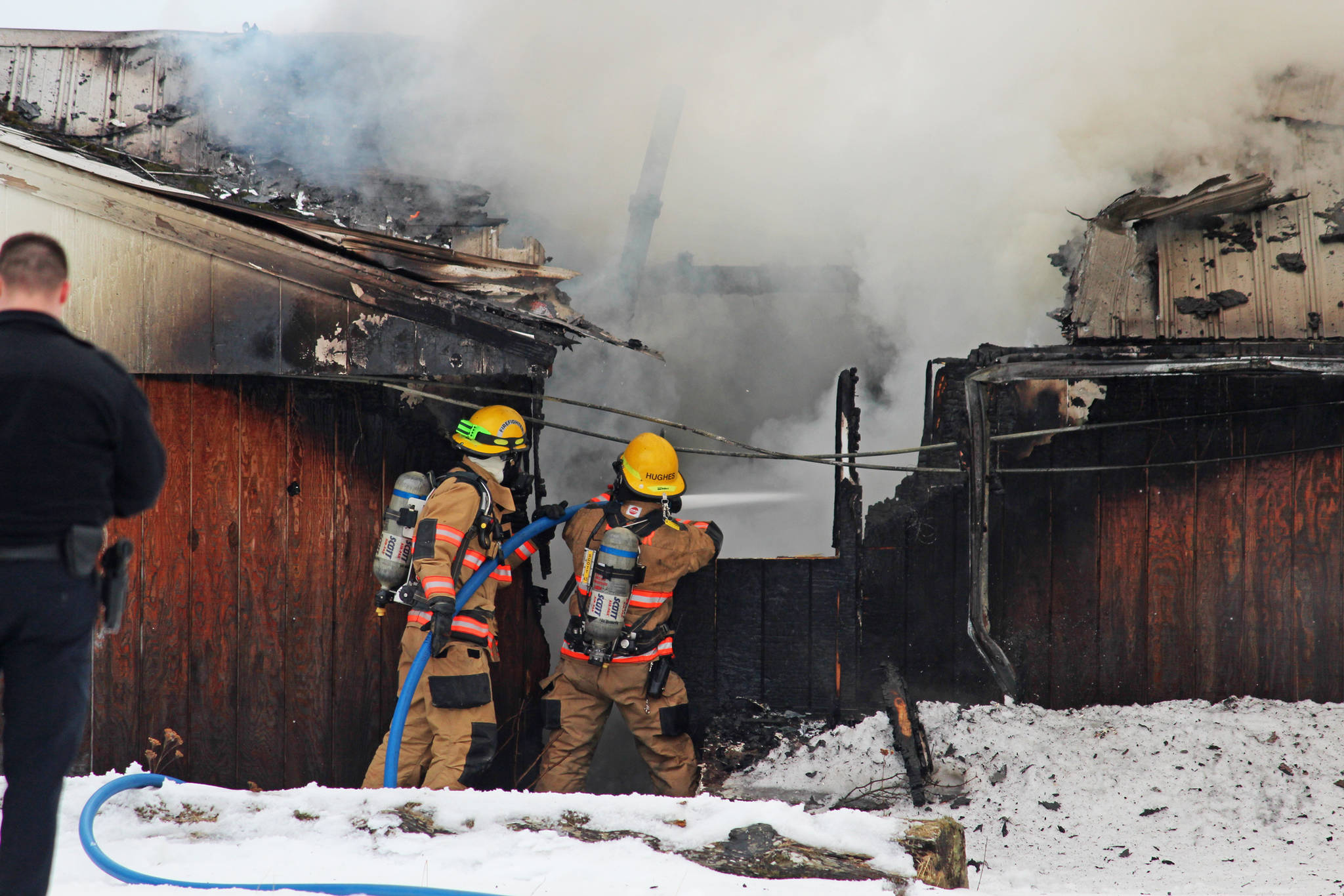 Firefighters douse a blaze that engulfed the old Bay View Inn on the Sterling Highway near the Baycrest Overlook on Thursday, March 7, 2019 in Homer, Alaska. (Photo by Megan Pacer/Homer News)