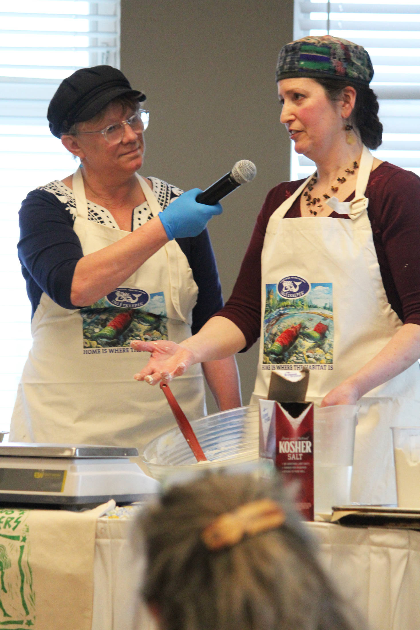 Carri Thurman, left, and Sharon Roufa, right, present a cooking demo on baking with sourdough Saturday, March 9, 2019 at the Alaska Food Festival at Land’s End Resort in Homer, Alaska. (Photo by Megan Pacer/Homer News)