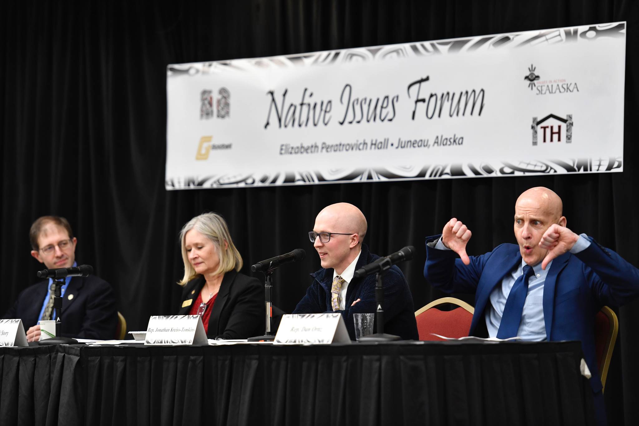 Rep. Dan Ortiz, I-Ketchikan, right, reacts as Rep. Jonathan Kreiss-Tompkins, D-Sitka, mentions a bill to move legislative meetings to Anchorage as they speak at the Native Issues Forum with Sen. Jesse Kiehl, D-Juneau, left, and Rep. Andi Story, D-Juneau, in the Elizabeth Peratrovich Hall on Wednesday, March 13, 2019. (Michael Penn | Juneau Empire)