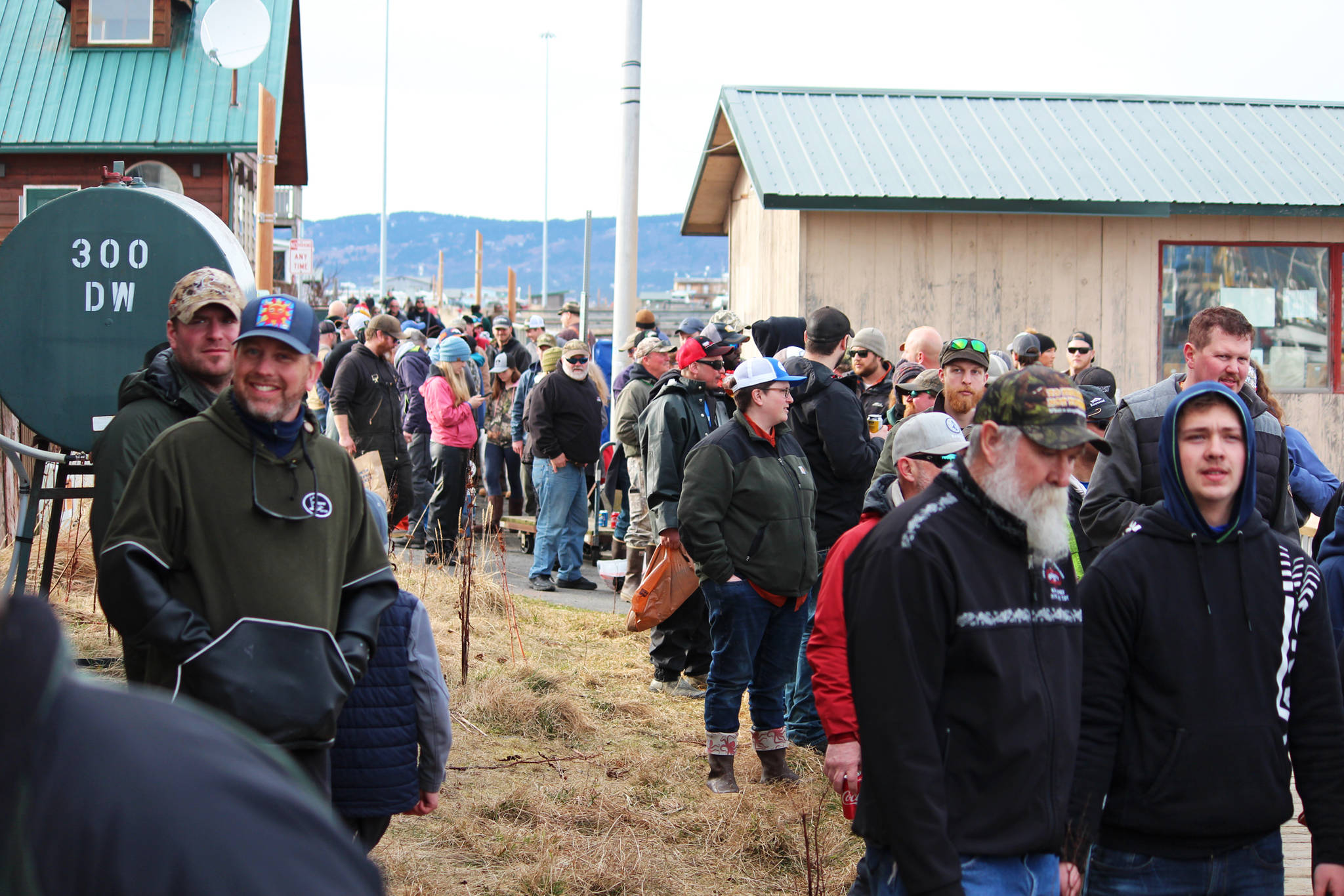Anglers que up to have their catches weighed at Coal Point Seafoods during the Homer Winter King Salmon Tournament held Saturday, March 23, 2019 in Homer, Alaska. (Photo by Megan Pacer/Homer News)