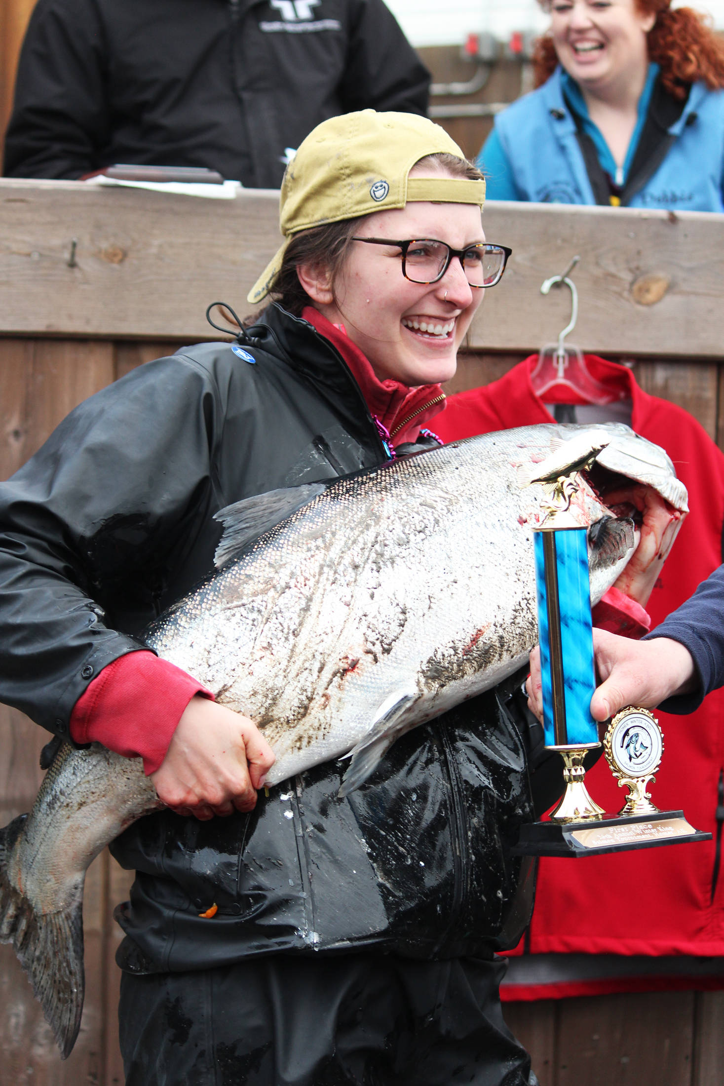 Shayna Perry of Eagle River holds up her 26.7-pound white king salmon while accepting first prize in the Homer Winter King Salmon Tournament on Saturday, March 23, 2019 at Coal Point Seafoods in Homer, Alaska. Perry is the first woman to win the tournament, according to the Homer Chamber of Commerce and Visitor Center. (Photo by Megan Pacer/Homer News)