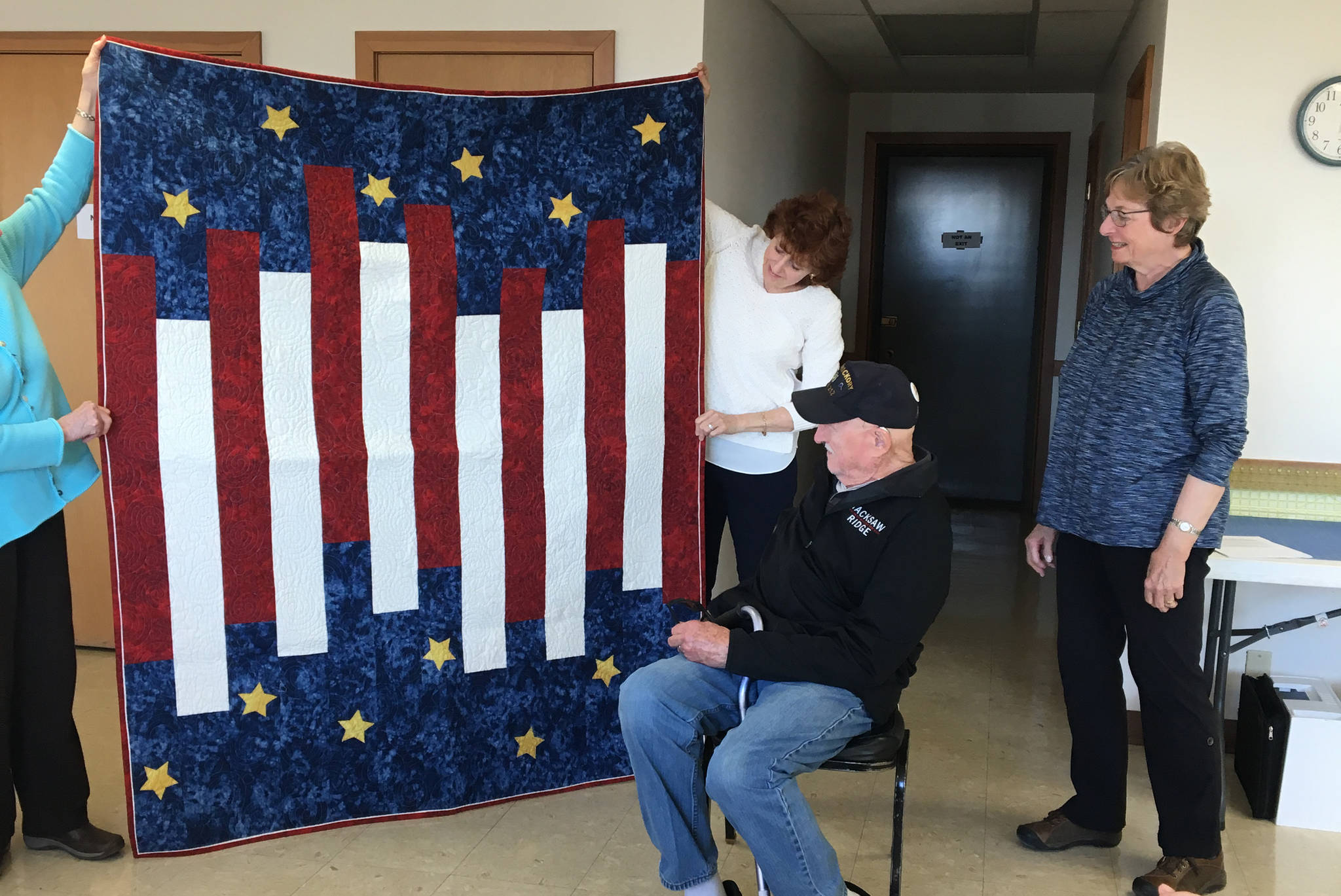 Sandy Mazen looks at the Quilt of Valor made for him by Lorraine Murphy, right, of the Kachemak Bay Quilters. Mazen received the quilt on April 4, 2019, at Kachemak Community Center in Kachemak City, Alaska. (Photo provided)