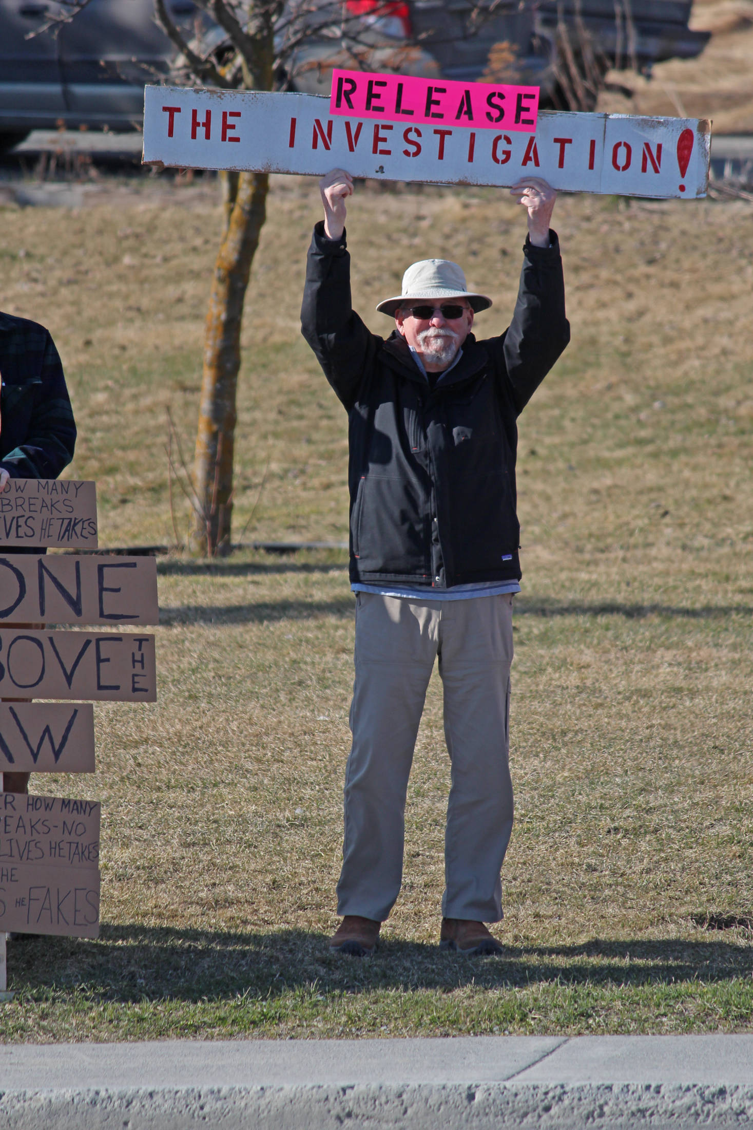 A local demonstrator stands with a sign at WKFL Park on Thursday, April 4, 2019 in Homer, Alaska, joining protests done nationally to prompt the release of special counsel Robert Mueller’s report of his investigation into Russian interference in the 2016 United States presidential election. (Photo by Megan Pacer/Homer News)