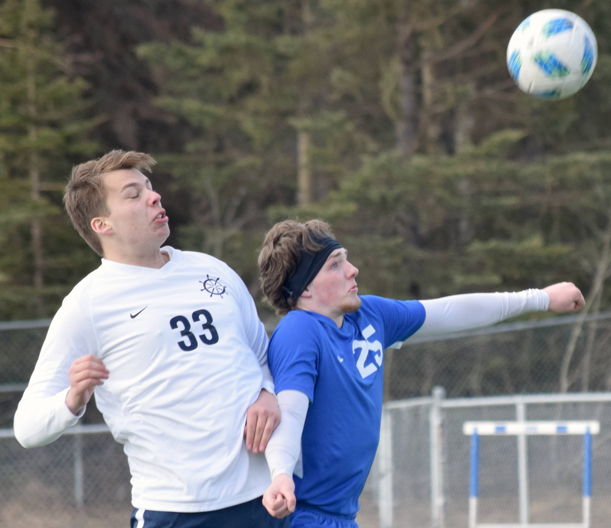 Homer’s Henry Russell and Soldotna’s Cameron Johnson battle for the ball Tuesday, April 9, 2019, at Soldotna High School in Soldotna, Alaska. (Photo by Jeff Helminiak/Peninsula Clarion)