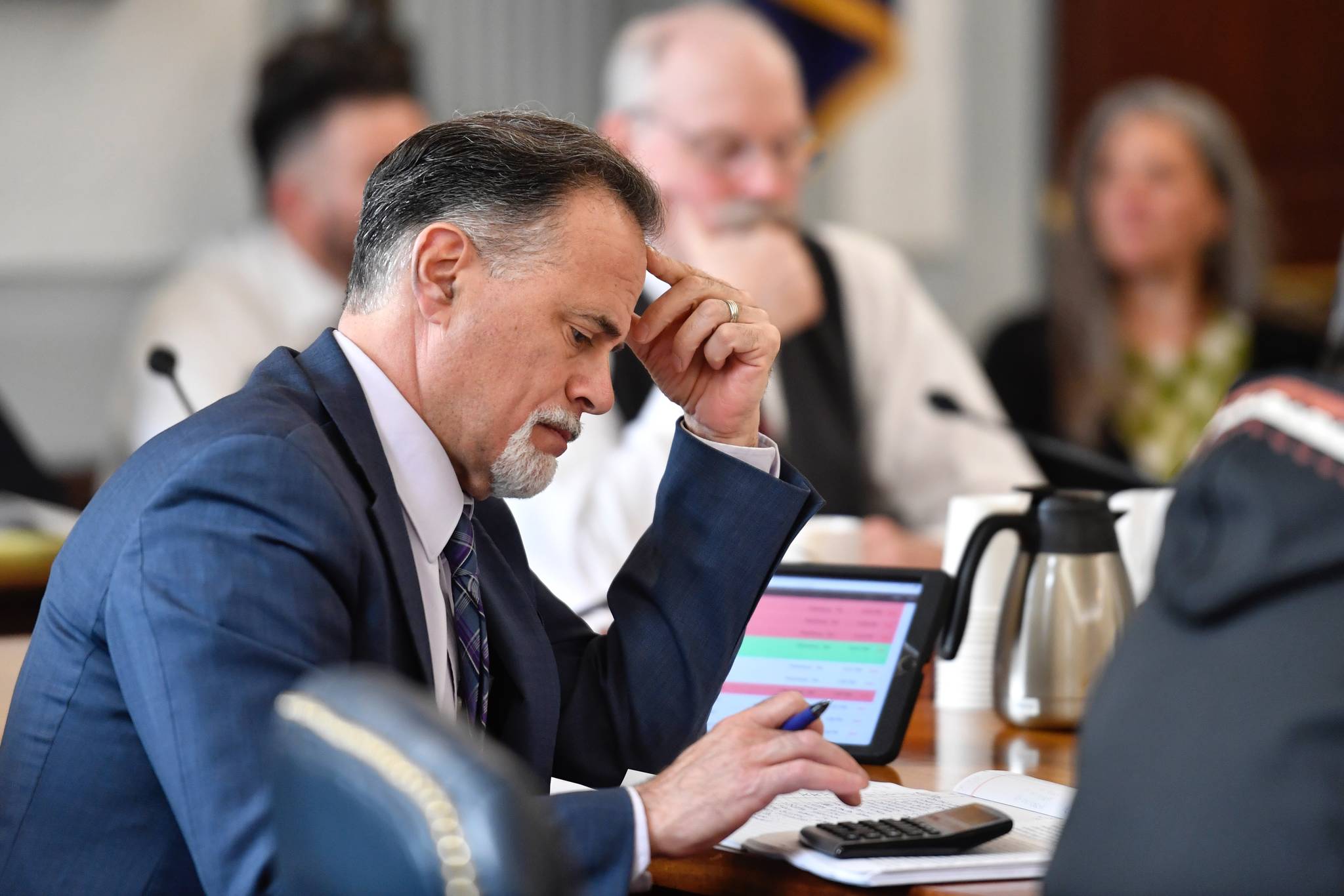 Sen. Peter Micciche, R-Soldotna, works a calculator as he and Sen. Bert Stedman, R-Sitka, listen to public testimony on the state budget in the Senate Finance Committee hearing on Friday, April 12, 2019. (Michael Penn | Juneau Empire)