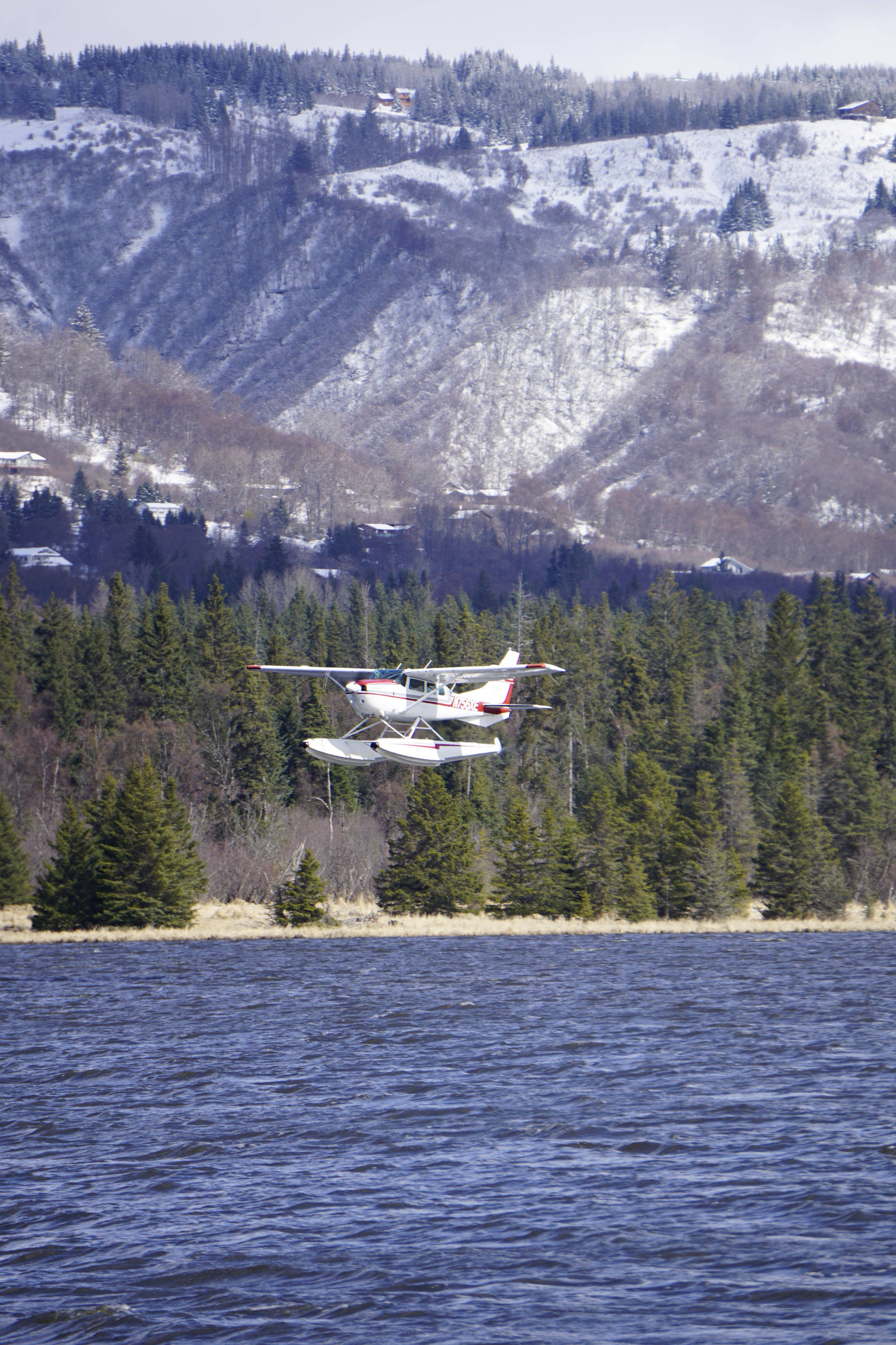 A floatplane takes off from Beluga Lake on Monday afternoon, April 22, 2019, in Homer, Alaska. Although a snow storm brought a taste of winter back to Homer after a deceptive spring, the lake remained open enough for float planes to start using it. (Photo by Michael Armstrong/Homer News)