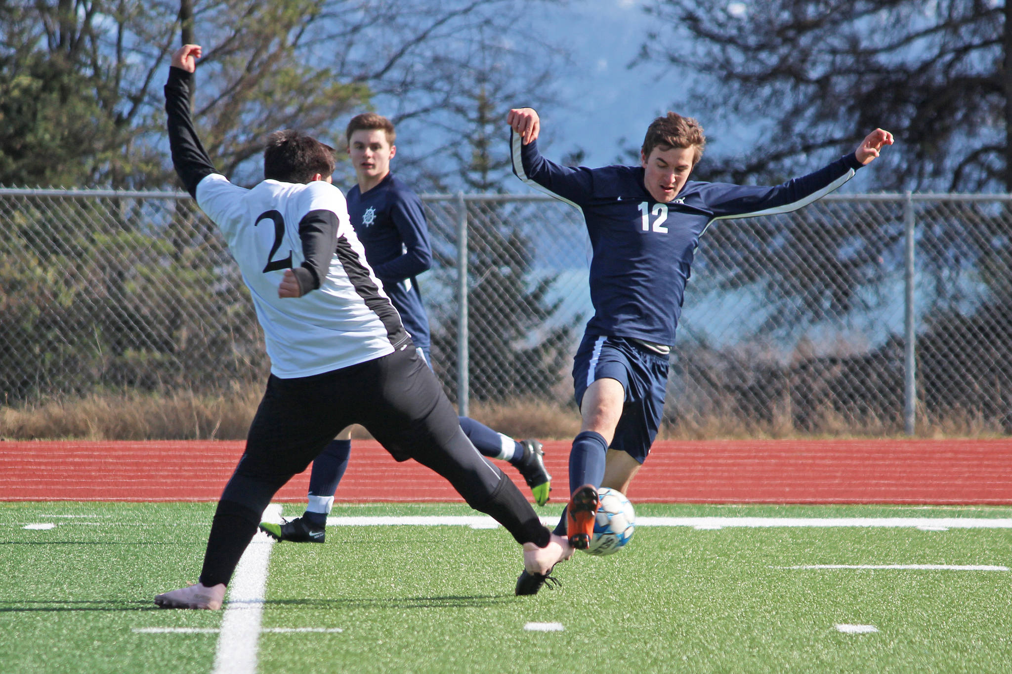 Nikiski’s Trevor Mysing and Homer’s Daniel Reutov connect over the ball during a soccer game Tuesday, April 23, 2019 at Homer High School in Homer, Alaska. (Photo by Megan Pacer/Homer News)