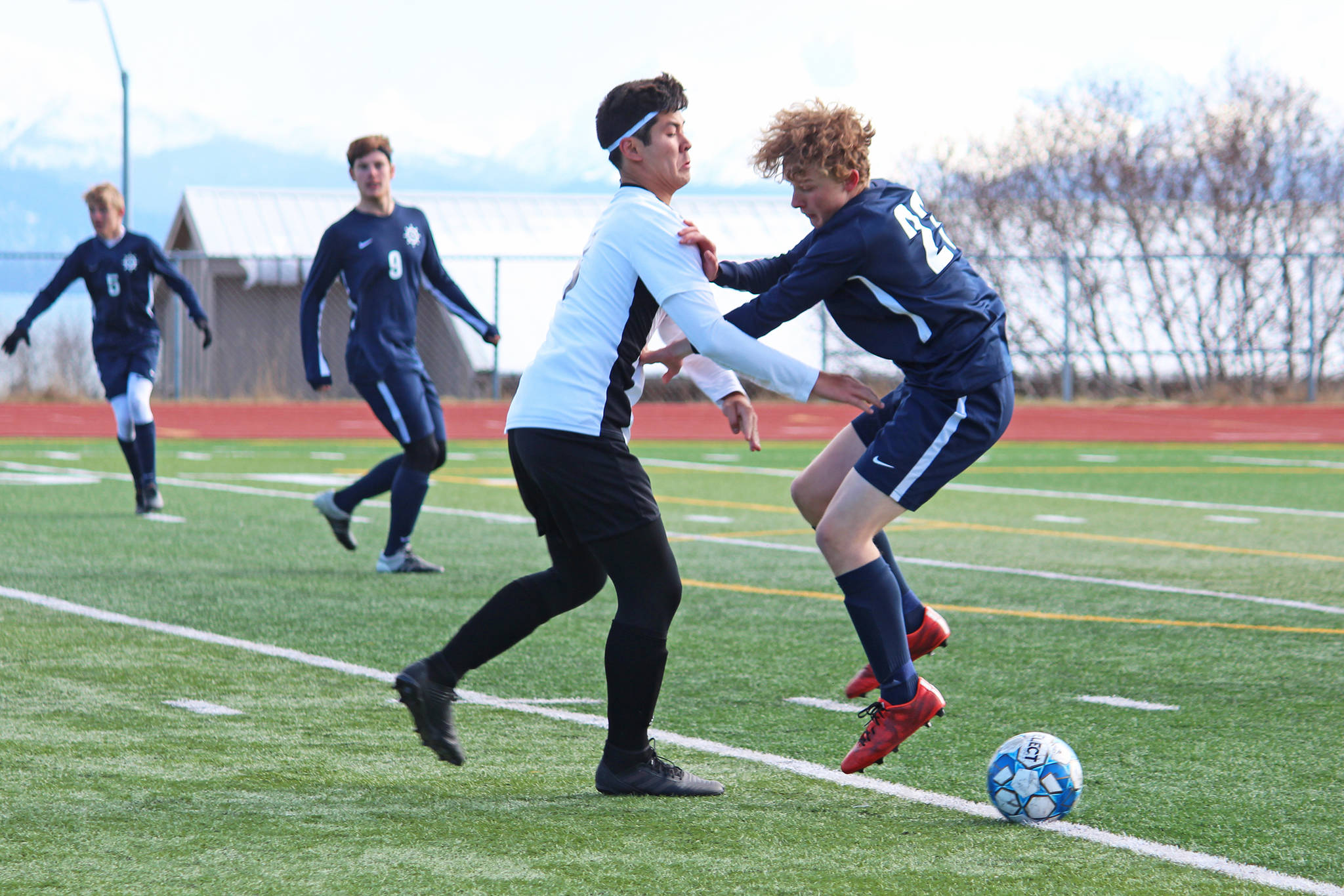 Homer’s Parker Lowney collides with Nikiski’s Shane Weathers during a soccer game Tuesday, April 23, 2019 at Homer High School in Homer, Alaska. (Photo by Megan Pacer/Homer News)