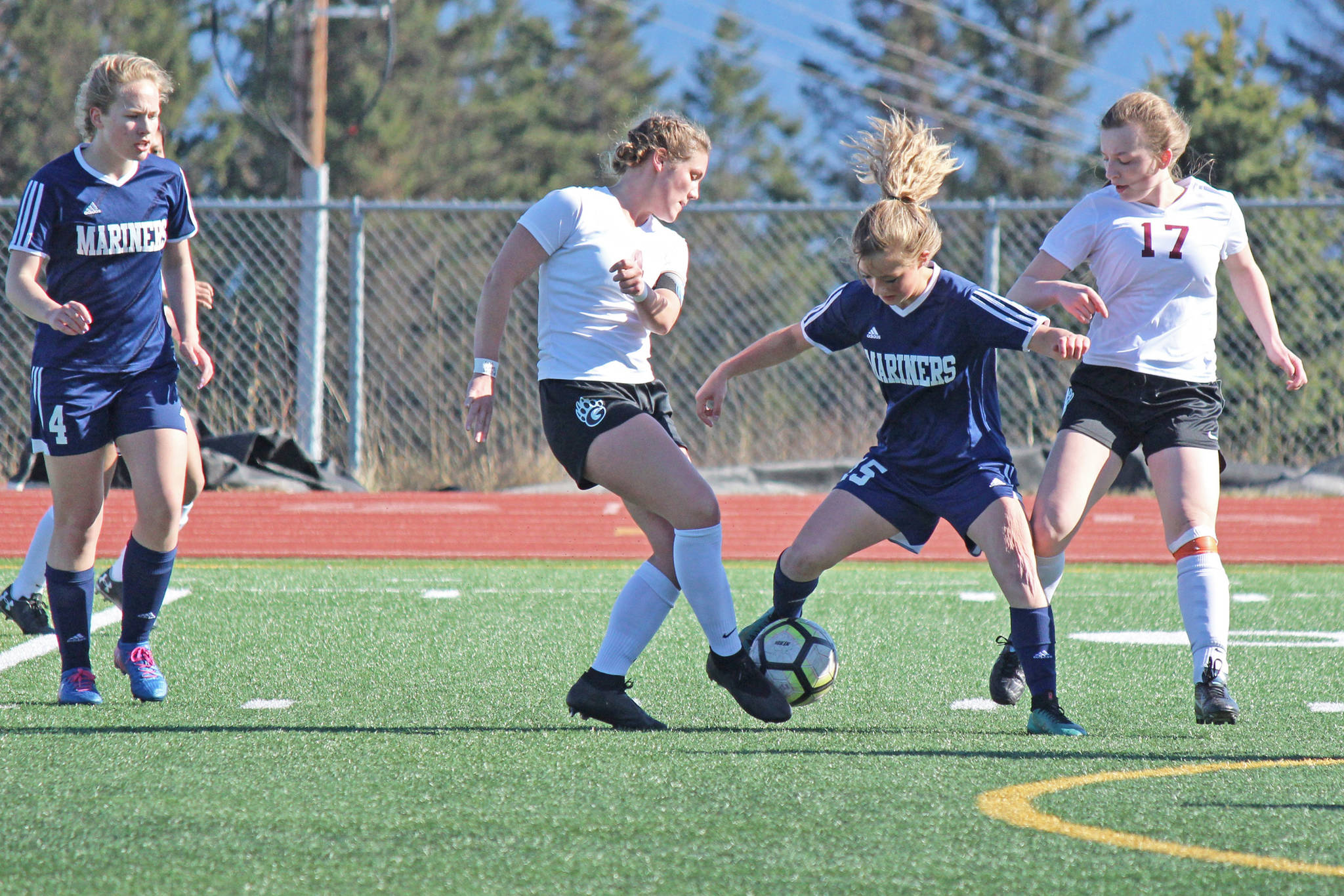 Homer Mariner Sela Weisser goes toe-to-toe with a Grace Action player during Friday’s varsity soccer game on April 26, 2019, at the high school in Homer, Alaska. Teammate Jessica Sonnen is ready to offer back-up. (Photo by McKibben Jackinsky)