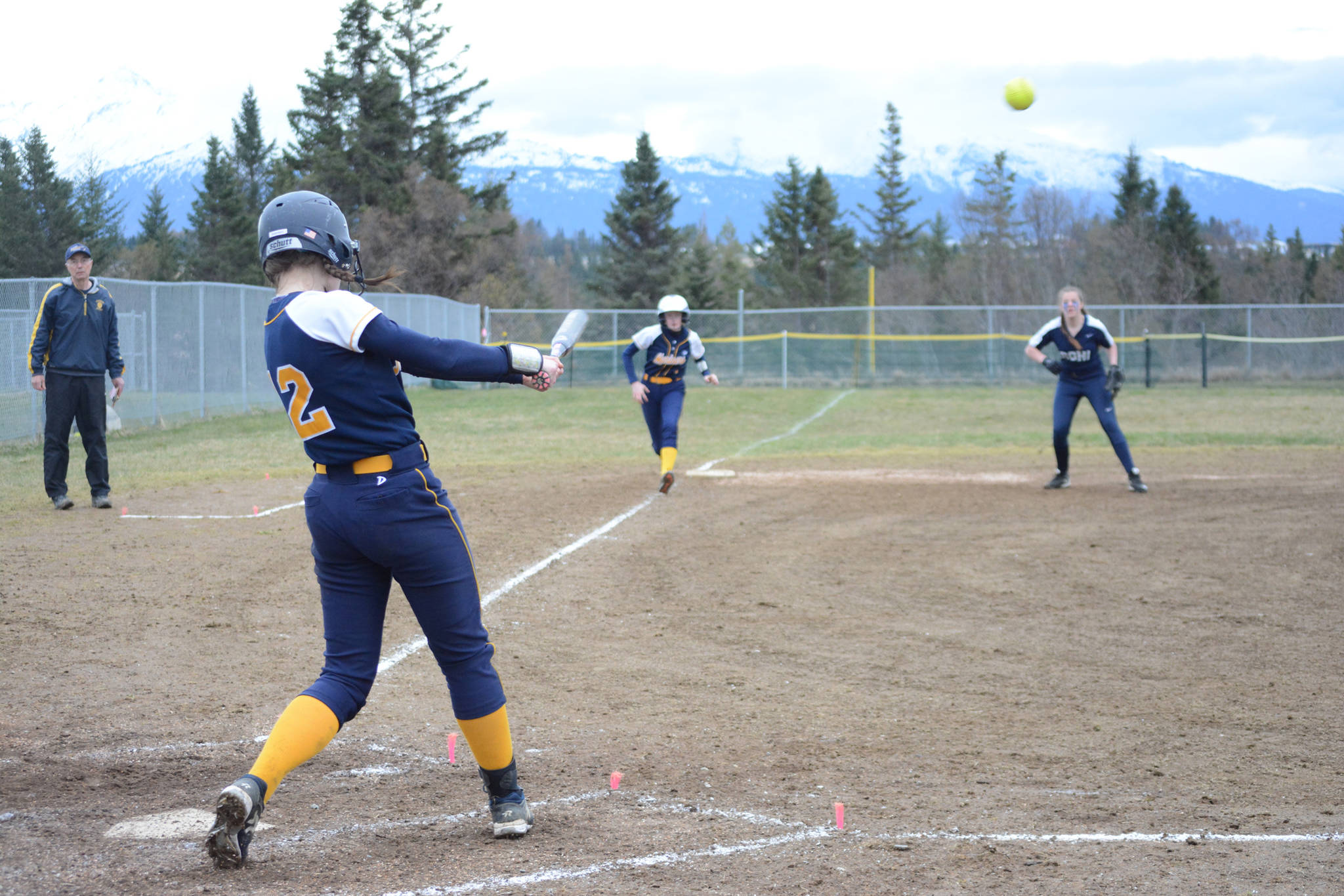Homer High School Mariners softball batter Grace Godfrey slams the ball as Becca Chapman prepares to run to home on Tuesday, April 30, 2019, against Soldotna High School at Jack Gist Park in Homer, Alaska. (Photo by Michael Armstrong/Homer News)
