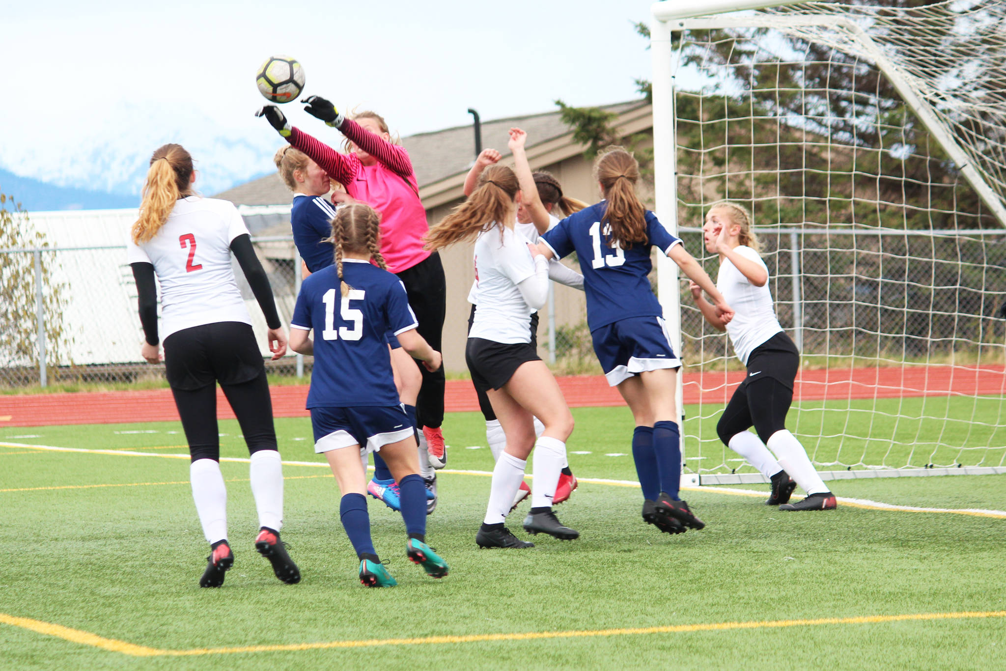 Kenai goal keeper Kailey Hamilton knocks the ball out of a pack of players during a Thursday, May 9, 2019 soccer game at Homer High School in Homer, Alaska. (Photo by Megan Pacer/Homer News)