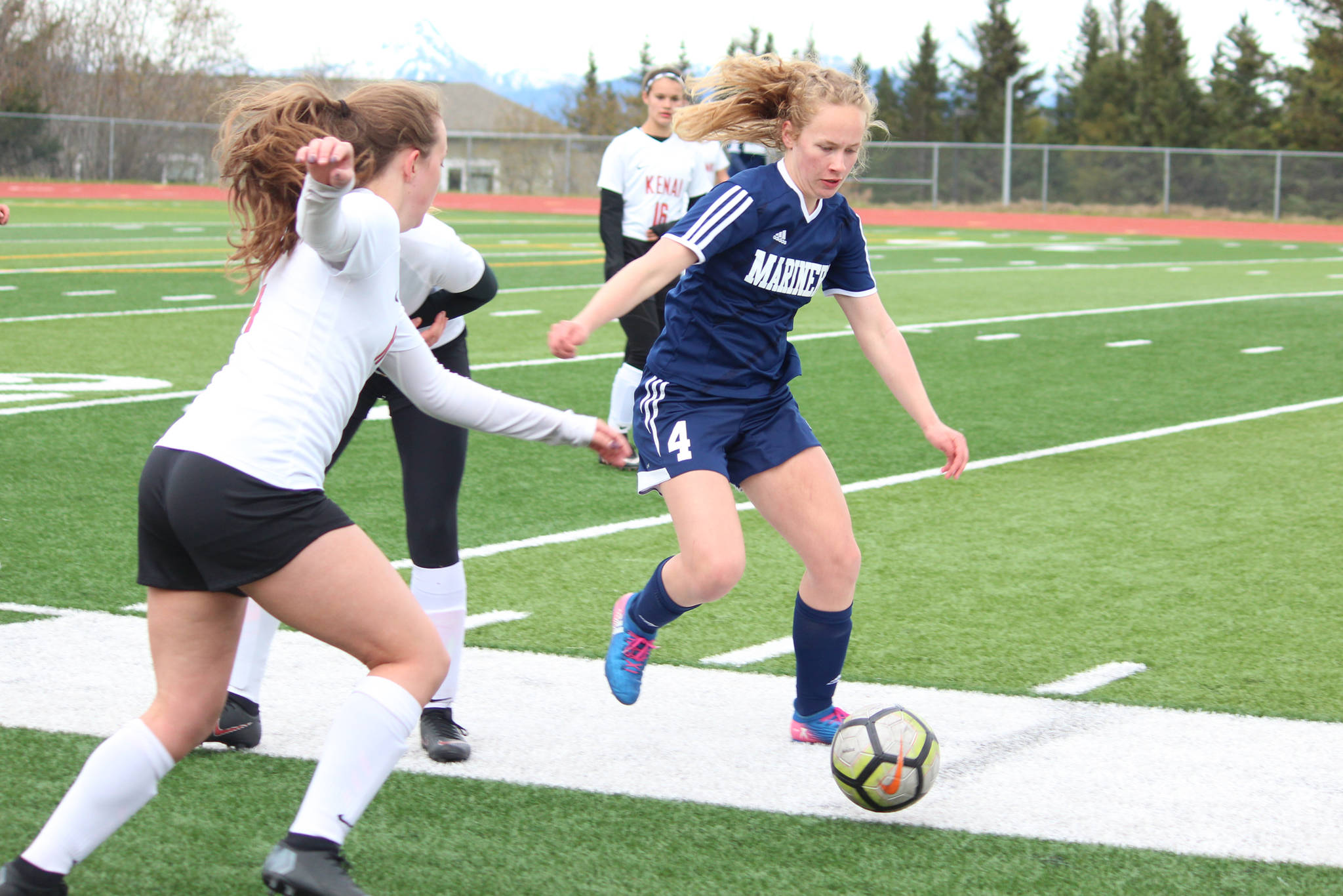 Homer’s Jessica Sonnen rushes to the ball along with Kenai’s Abigail Schneiders during a Thursday, May 9, 2019 soccer game at Homer High School in Homer, Alaska. (Photo by Megan Pacer/Homer News)