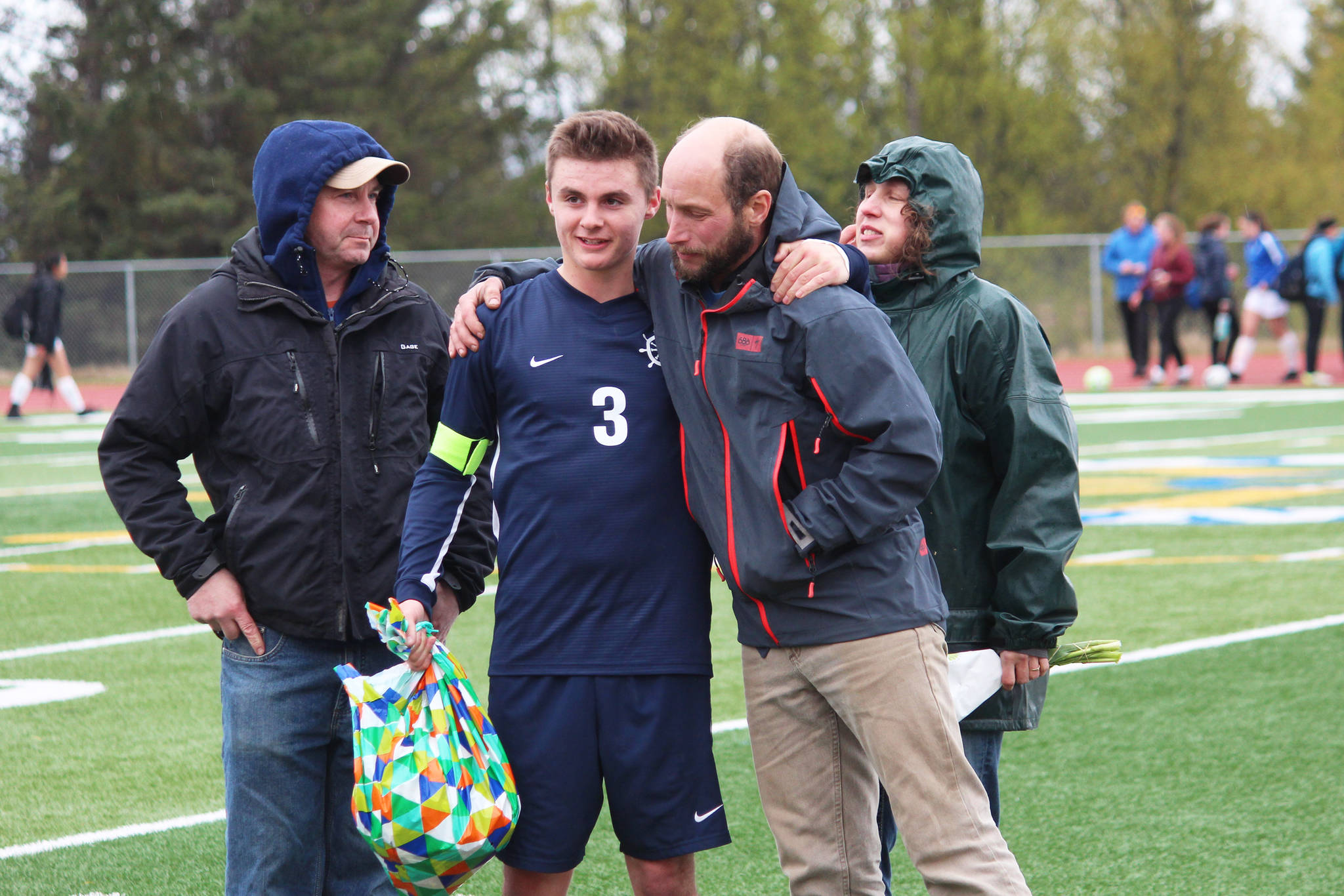 Defender Dexter Lowe celebrates with his parents while being recognized during Senior Night between the boys and girls soccer games Friday, May 10, 2019 at Homer High School in Homer, Alaska. (Photo by Megan Pacer/Homer News)