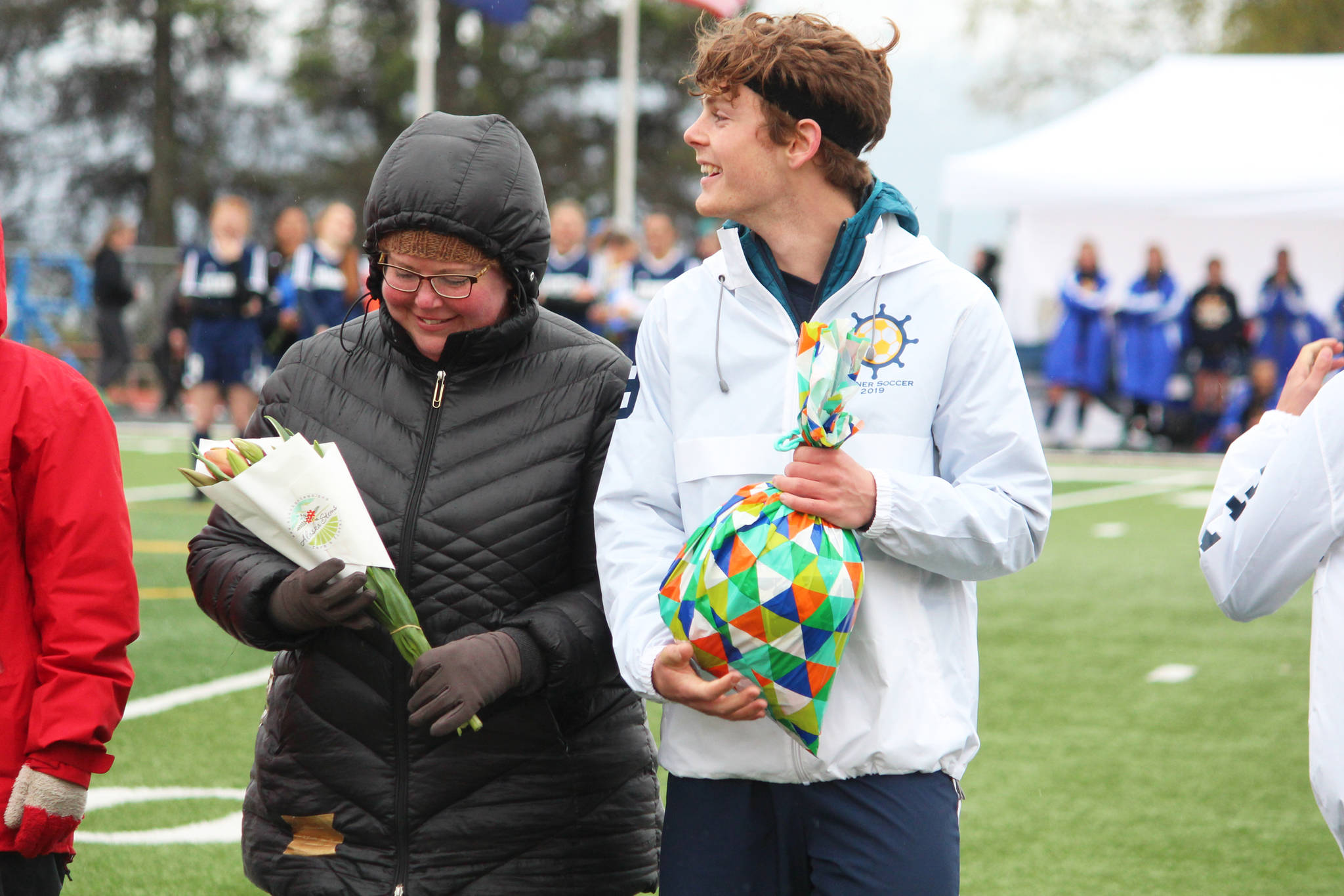 Defender Avram Salzmann stands with his mother while being recognized during a Senior Night celebration between the girls and boys soccer games against Thunder Mountain on Friday, May 10, 2019 at Homer High School in Homer, Alaska. (Photo by Megan Pacer/Homer News)
