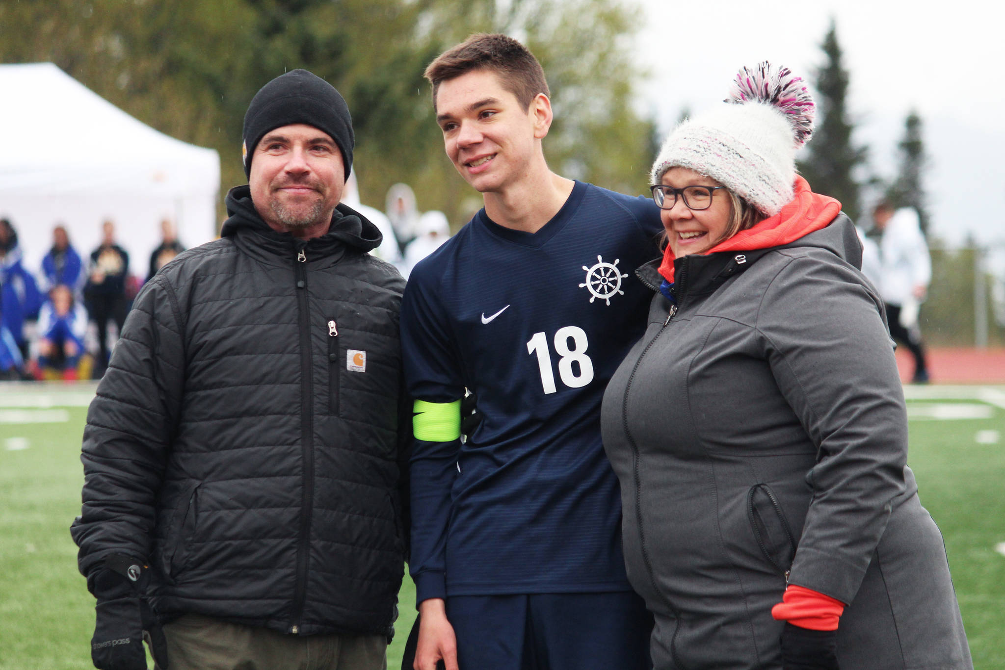 Midfielder Desmond VanLiere stands with his parents to be recognized during a Senior Night celebration Friday, May 10, 2019 between soccer games at Homer High School in Homer, Alaska. (Photo by Megan Pacer/Homer News)