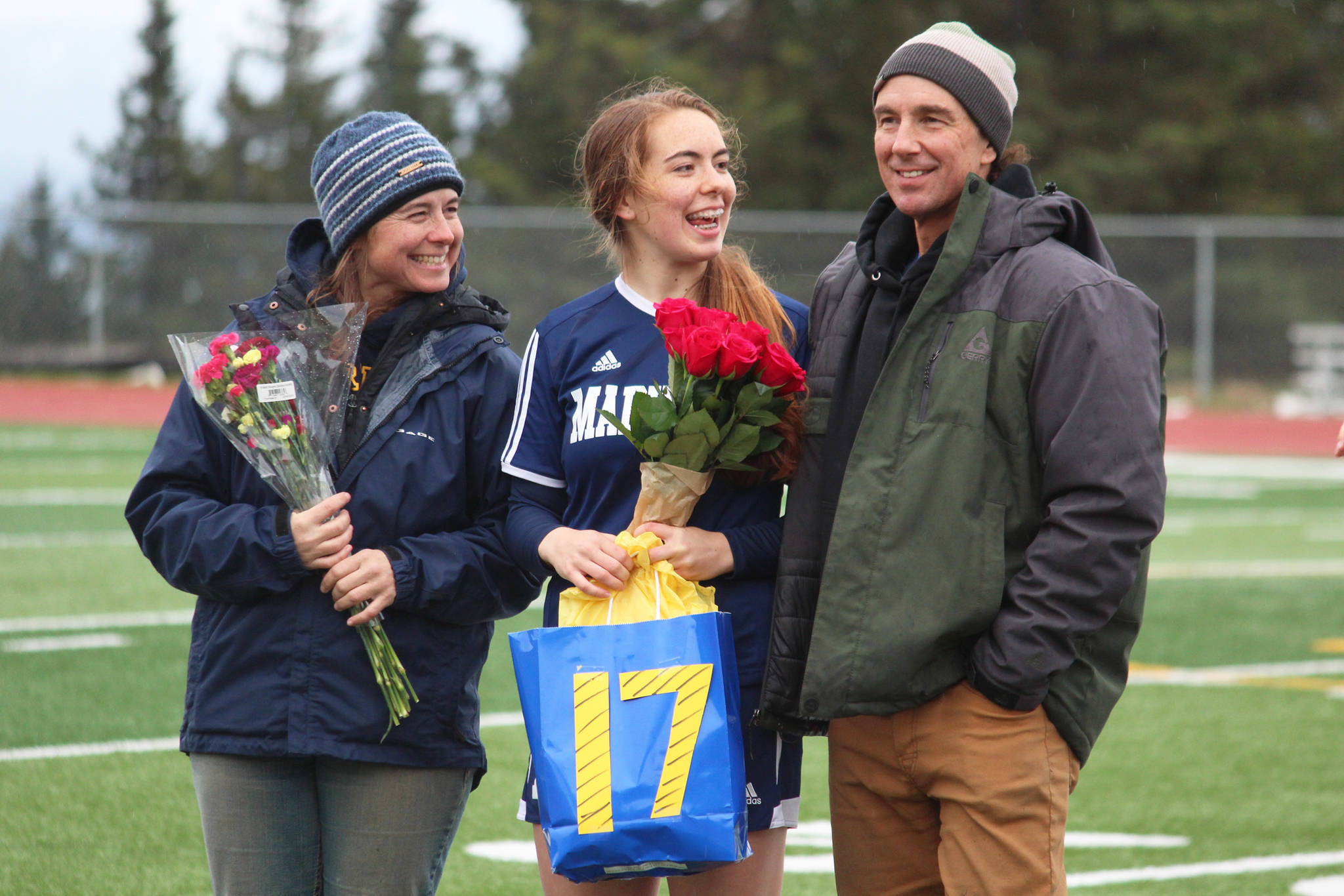 Defender Summer McGuire stands with her parents to be recognized during Senior Night between the girls and boys soccer games Friday, May 10, 2019 at Homer High School in Homer, Alaska. (Photo by Megan Pacer/Homer News)