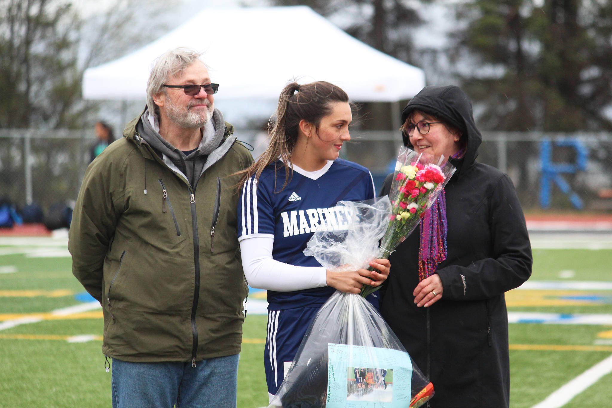 Defender and midfielder Kimberly Lynn celebrates with her parents while being recognized on Senior Night between games against Thunder Mountain on Friday, May 10, 2019 at Homer High School in Homer, Alaska. (Photo by Megan Pacer/Homer News)