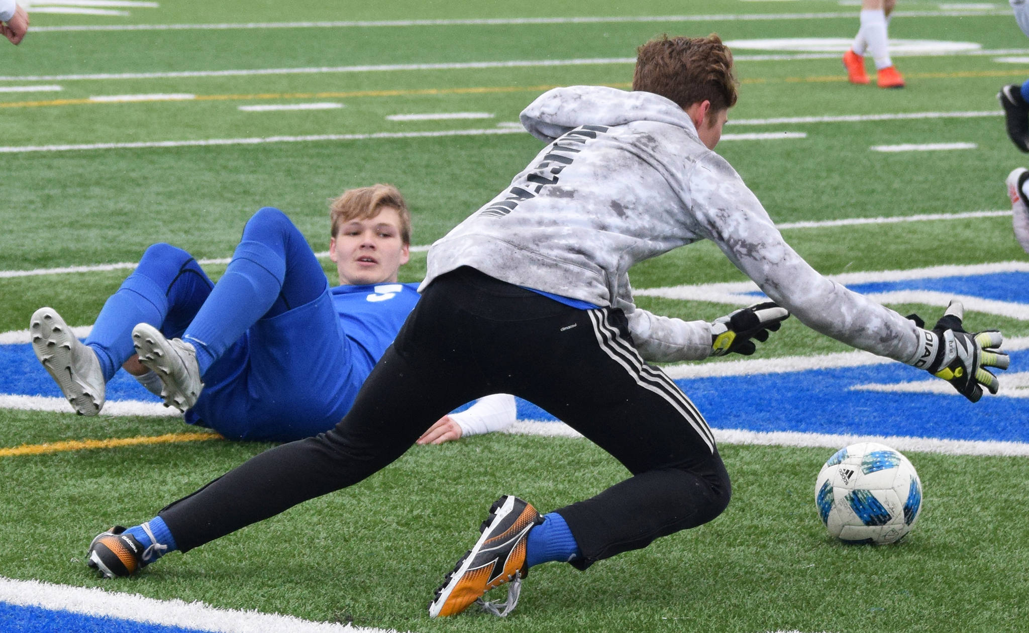 Soldotna’s Rory Nelson watches as SoHi goalkeeper Colton Sorhus (forwar) falls on the ball Saturday against Homer in a Peninsula Conference game in Soldotna. (Photo by Joey Klecka/Peninsula Clarion)