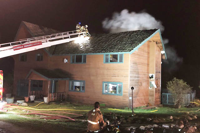 Kachemak Emergency Services firefighters use a ladder truck to attack flames in the roof of a Hancock Drive home early on May 8, 2019, in Homer, Alaska. (Photo provided)