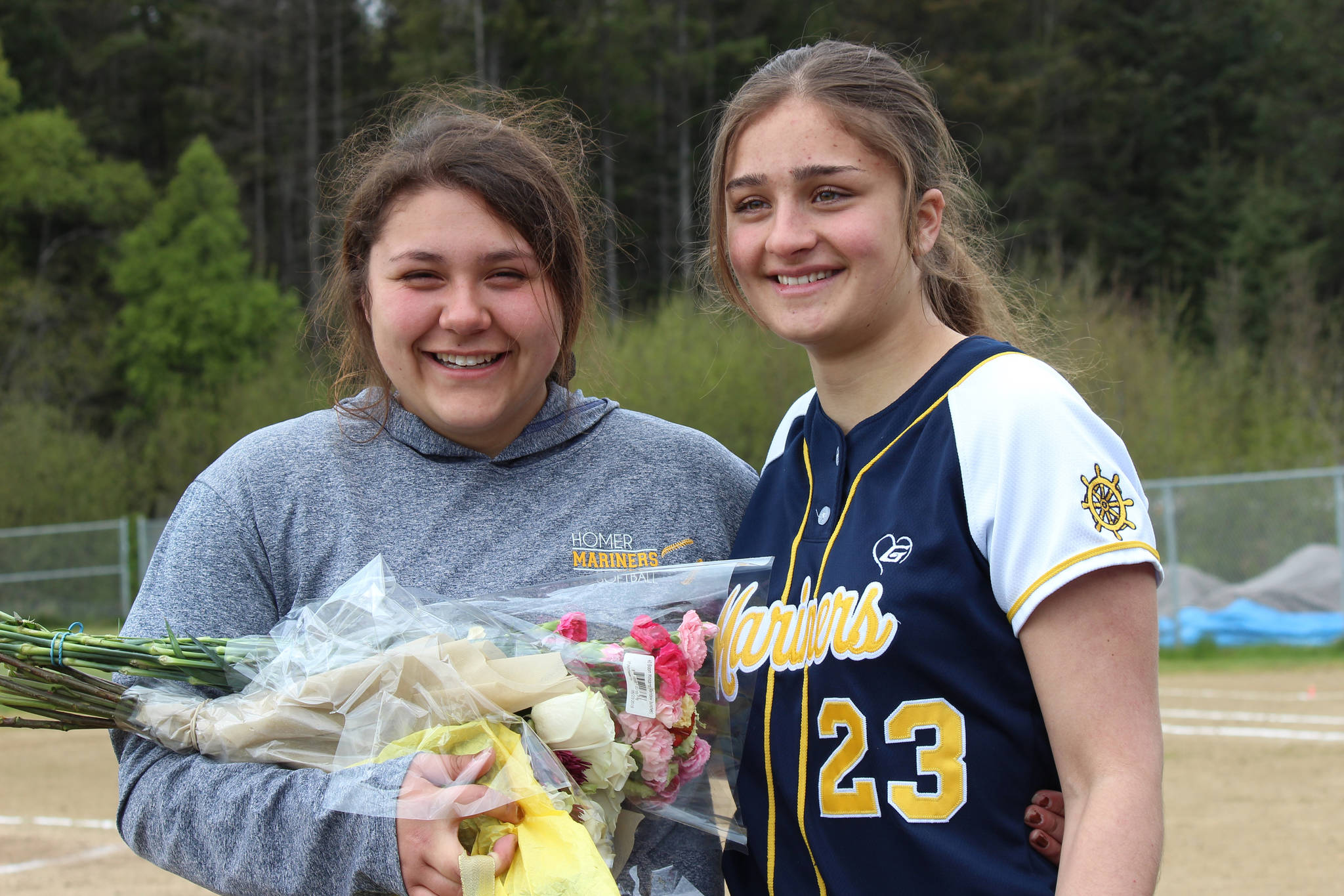 Senior Brianna Hetrick, left, and foreign exchange student Claudia Fernandez, right, were honored prior to the Mariners’ softball game against Kenai at the Jack Gist field on Saturday. (Photo by McKIbben Jackinsky )