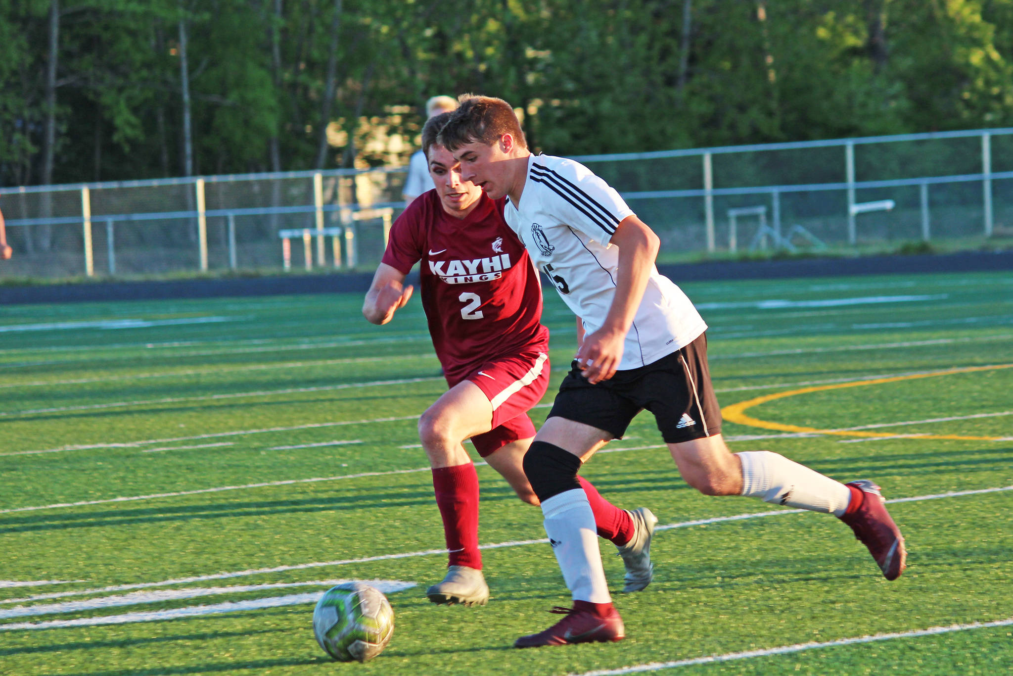 Ketchikan’s Jake Taylor (left) and Kenai’s Tucker Vann race to the ball during a Friday, May 24, 2019 semifinal match in the Division II state soccer championships at West Anchorage High School in Anchorage, Alaska. (Photo by Megan Pacer/Homer News)