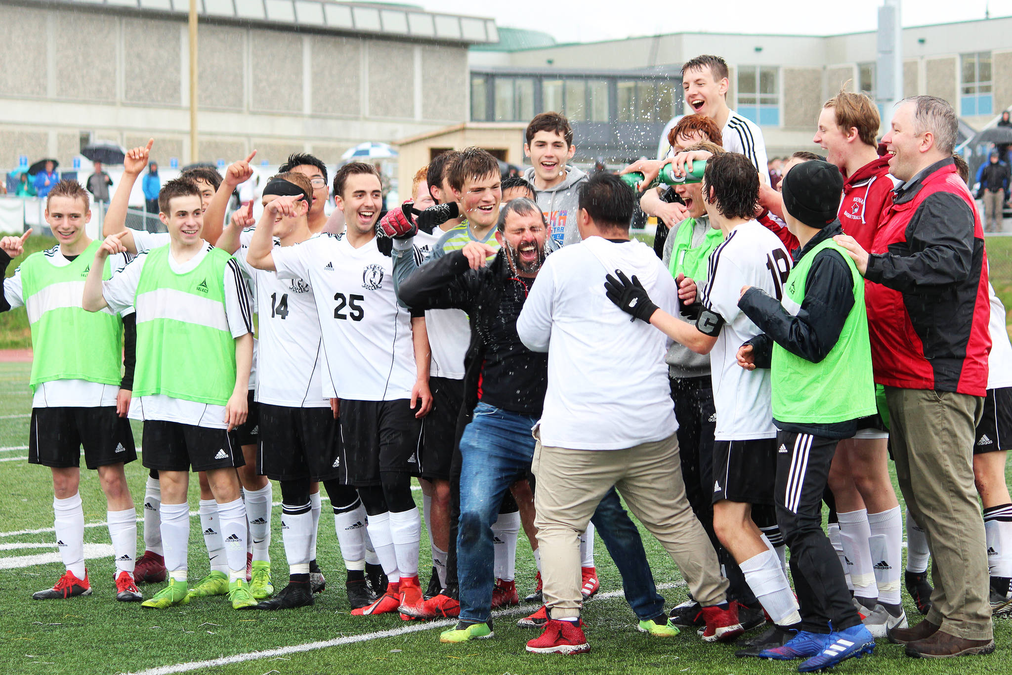Members of the Kenai boys soccer team dump water on their head coach, Shane Lopez, in celebration of their win over Juneau on Saturday, May 25, 2019 to claim the Division II state soccer championship title. The game was played at Service High School in Anchorage, Alaska. (Photo by Megan Pacer/Homer News)