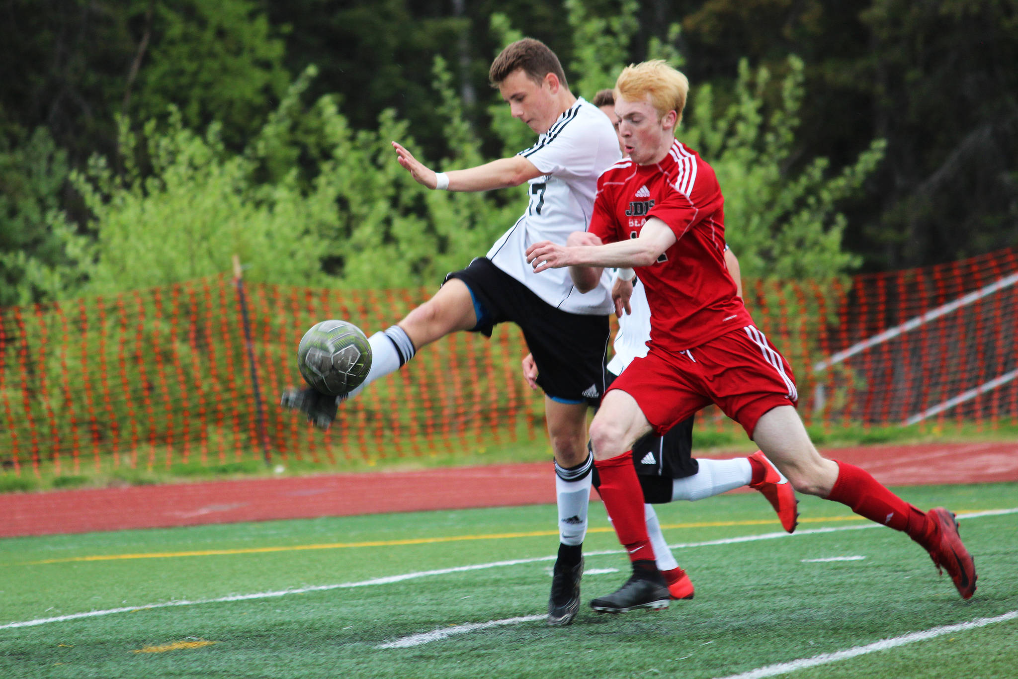 Kenai defender Travis Verkuilen clears the ball while under pressure from Juneau’s Kannon Goetz during the champioship match of the Division II state soccer tournament Saturday, May 25, 2019 at Service High School in Anchorage, Alaska. (Photo by Megan Pacer/Homer News)