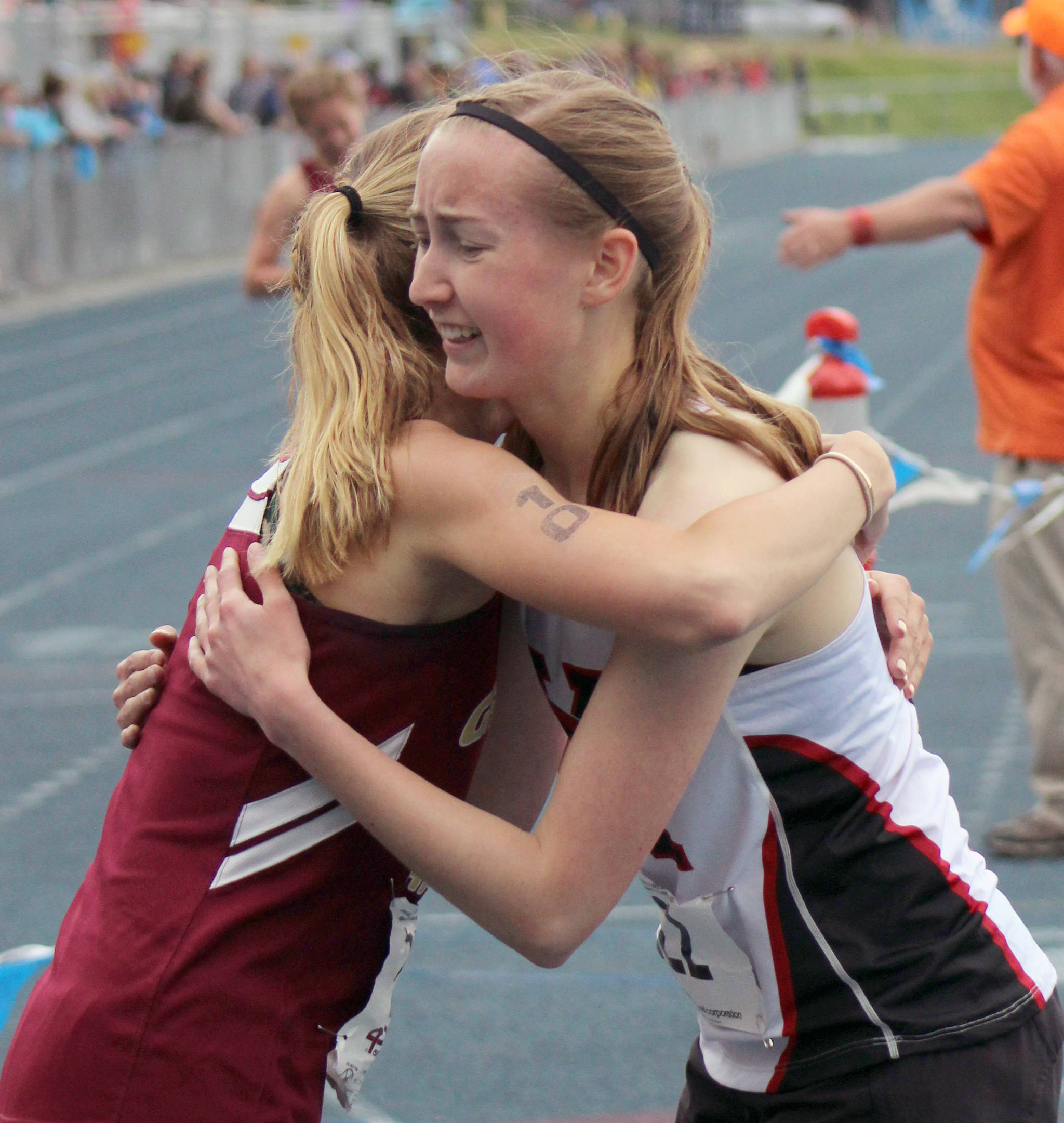 Kenai Central’s Jaycie Calvert hugs competitor Mazzy Jackson of Grace Christian on Saturday at Palmer High School at the state track and field meet. (Photo by Tim Rockey/Frontiersman)
