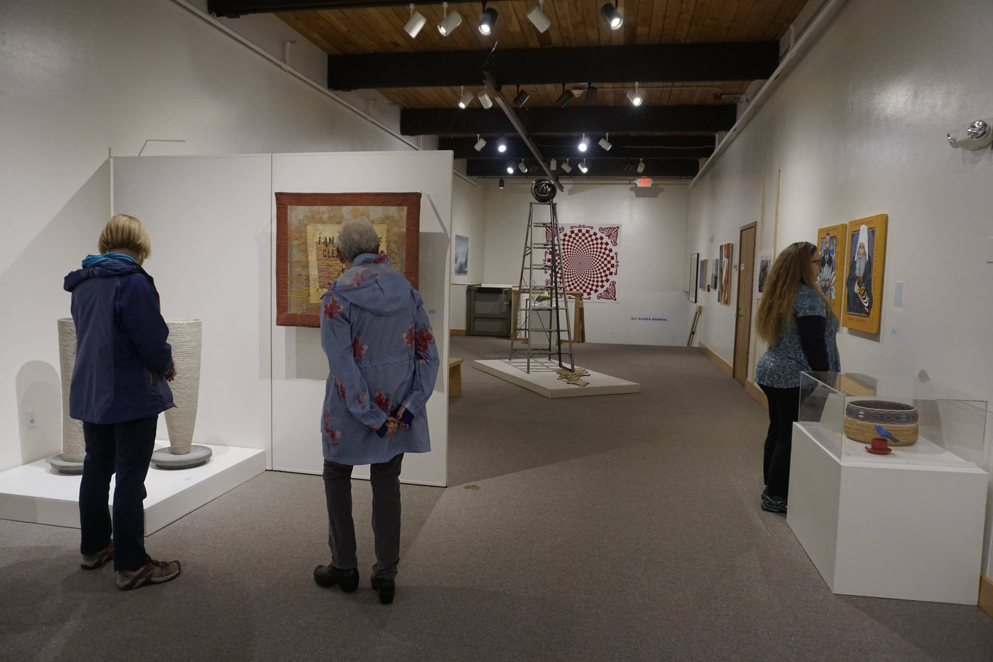 Visitors view the All Alaska Biennial exhibit at the Pratt Museum for its grand reopening on May 25, 2019, in Homer, Alaska. The Special Exhibits Gallery staircase at back was redone to expand the gallery space and add a three-stop lift. (Photo by Michael Armstrong/Homer News)