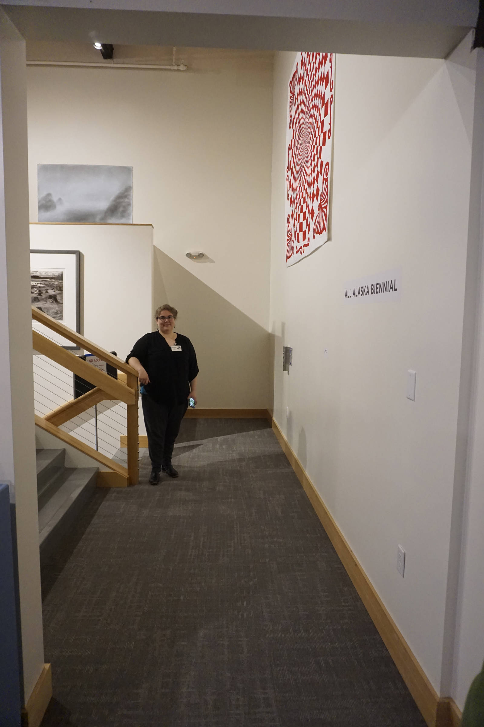 Savanna Bradley, Pratt Museum collections manager, stands in the newly remodeled mezzanine off the special exhibits gallery on May 28, 2019, in Homer, Alaska. The floor was raised to be on the same level as the Marine Gallery, with a new door connecting them. A three-stop left behind Bradley offers handicapped access to the main floor, the Marine Gallery, and the lower level. (Photo by MIchael Armstrong/Homer News)